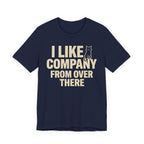 A navy short-sleeve t-shirt with a beige graphic print that reads "I Like Company From Over There" with an unimpressed sitting cat