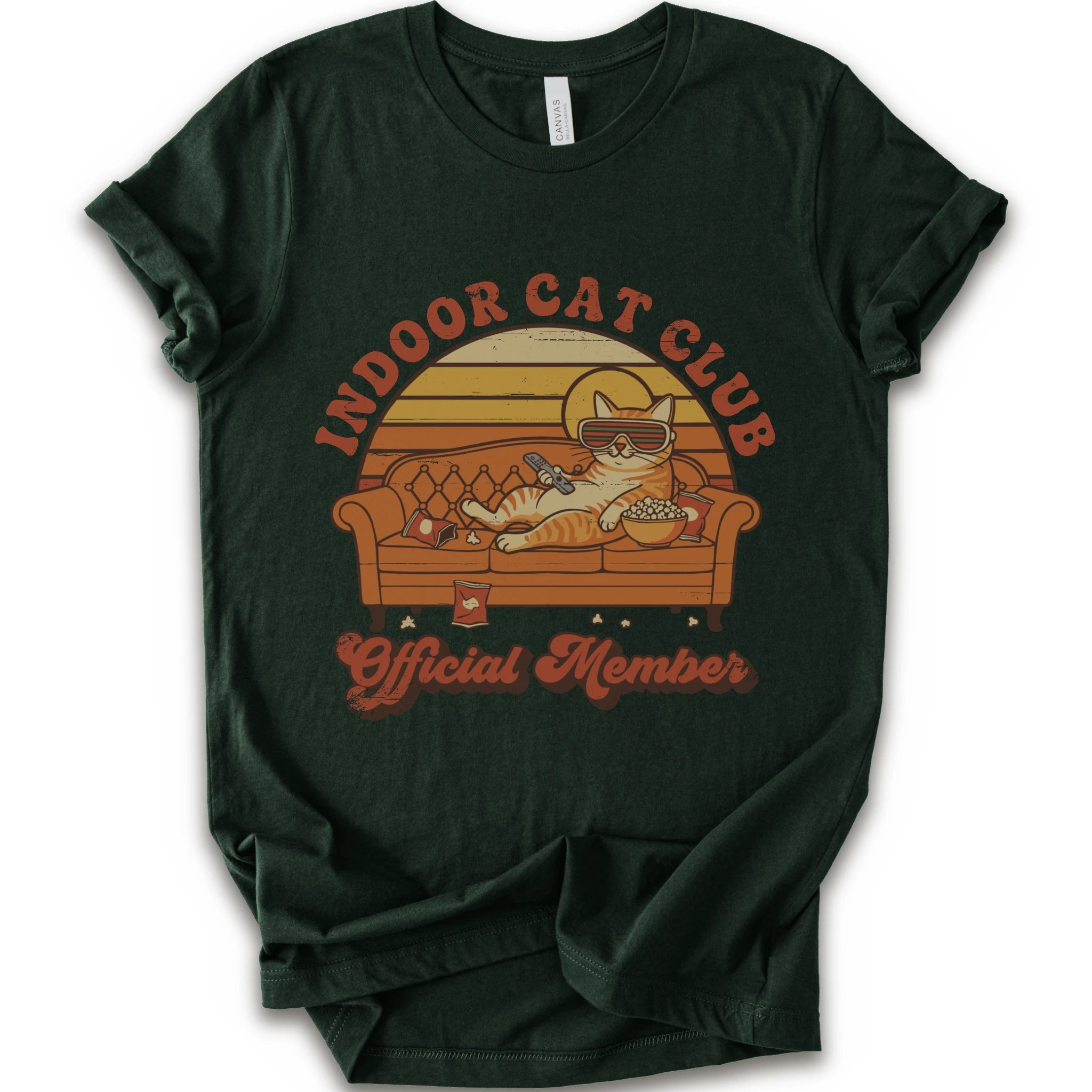 A forest short-sleeve crewneck t-shirt featuring a retro-style graphic of a cat lounging on a couch with the text 'INDOOR CAT CLUB' and 'Official Member' in orange-brown lettering.