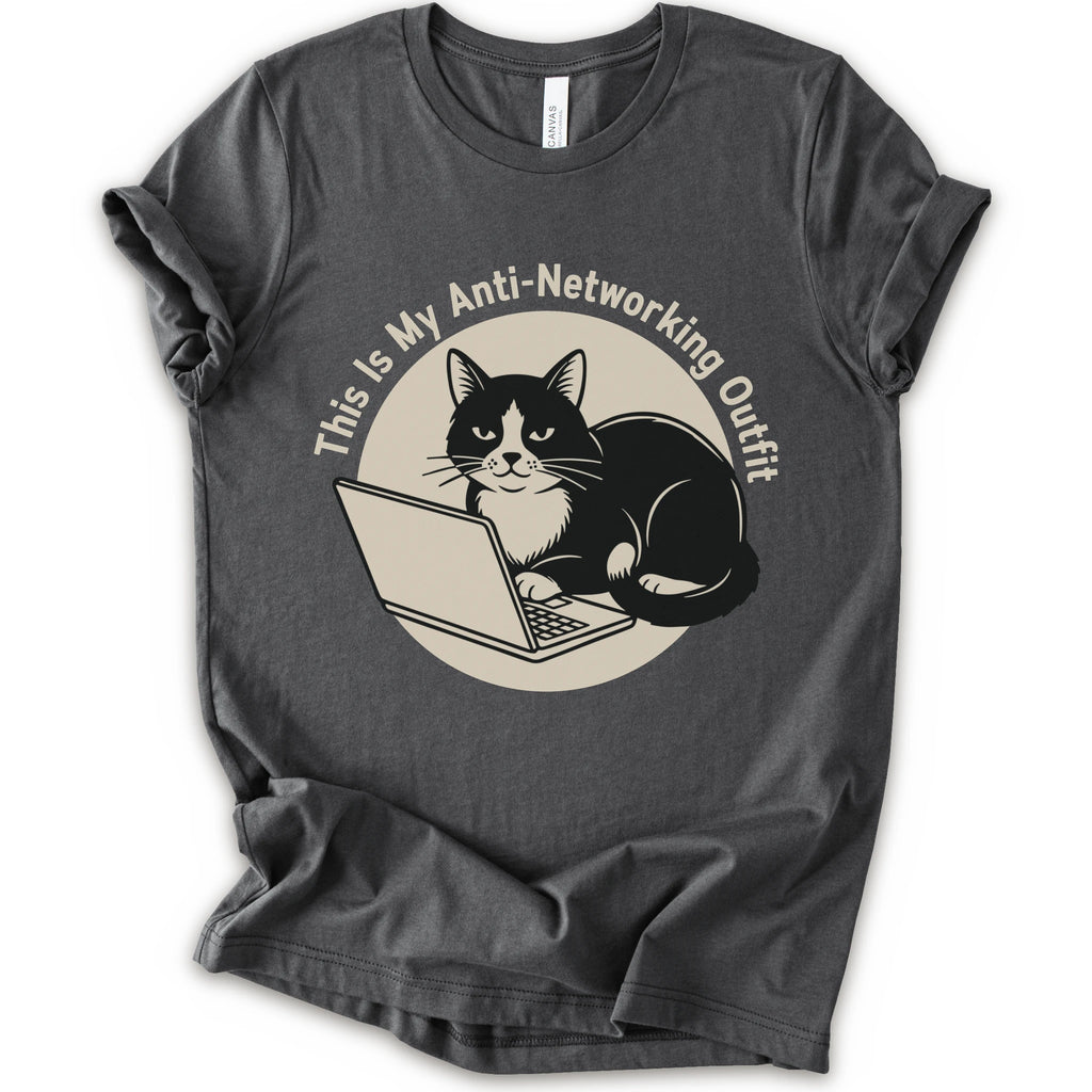 A asphalt T-shirt with a “This Is My Anti-Networking Outfit” curves above a black-and-white cat sitting at an open laptop. The artwork uses a clean circular badge layout with a limited black-and-cream palette.