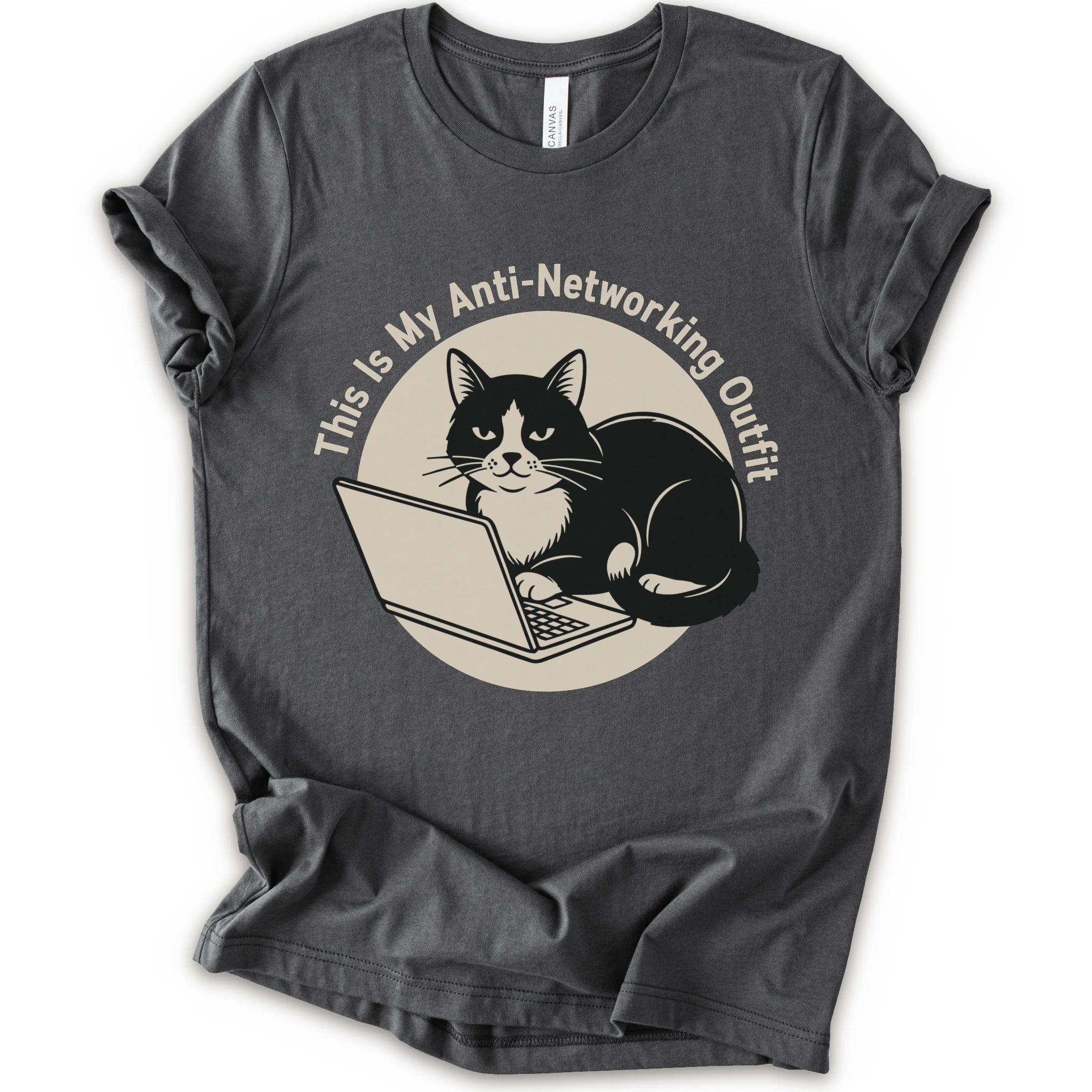 A asphalt T-shirt with a “This Is My Anti-Networking Outfit” curves above a black-and-white cat sitting at an open laptop. The artwork uses a clean circular badge layout with a limited black-and-cream palette.