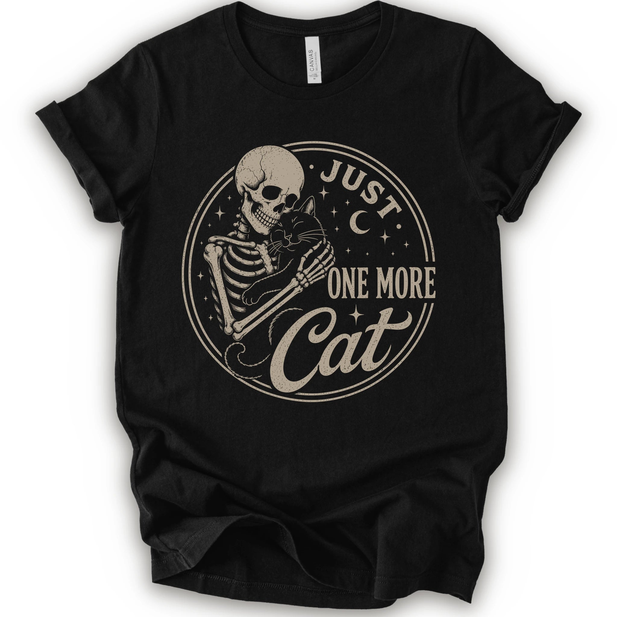 A black short-sleeve crewneck t-shirt with a distressed beige graphic of a skeleton holding a cat, surrounded by the text 'JUST ONE MORE Cat' inside a circular design.