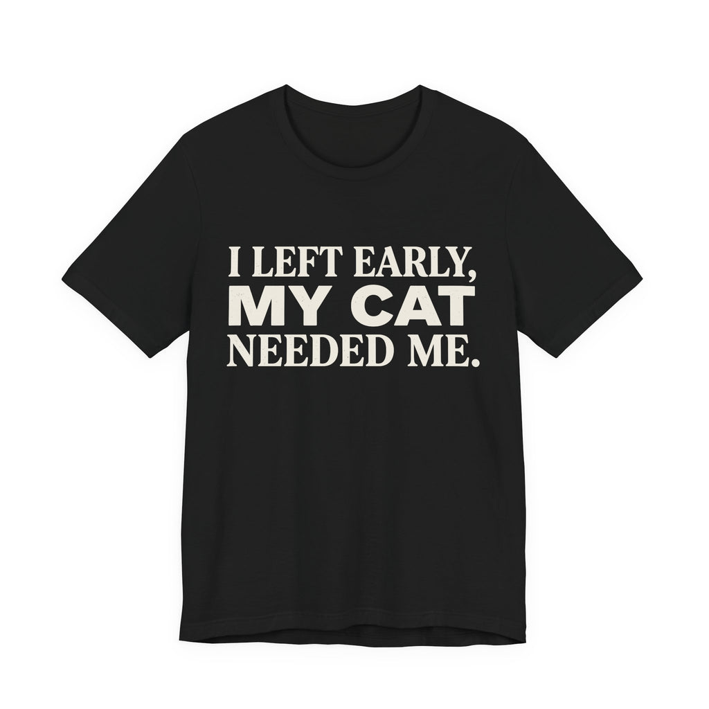 A black short-sleeve crewneck t-shirt featuring a graphic with cream text reading “I Left Early, My Cat Needed Me” arranged in three bold lines