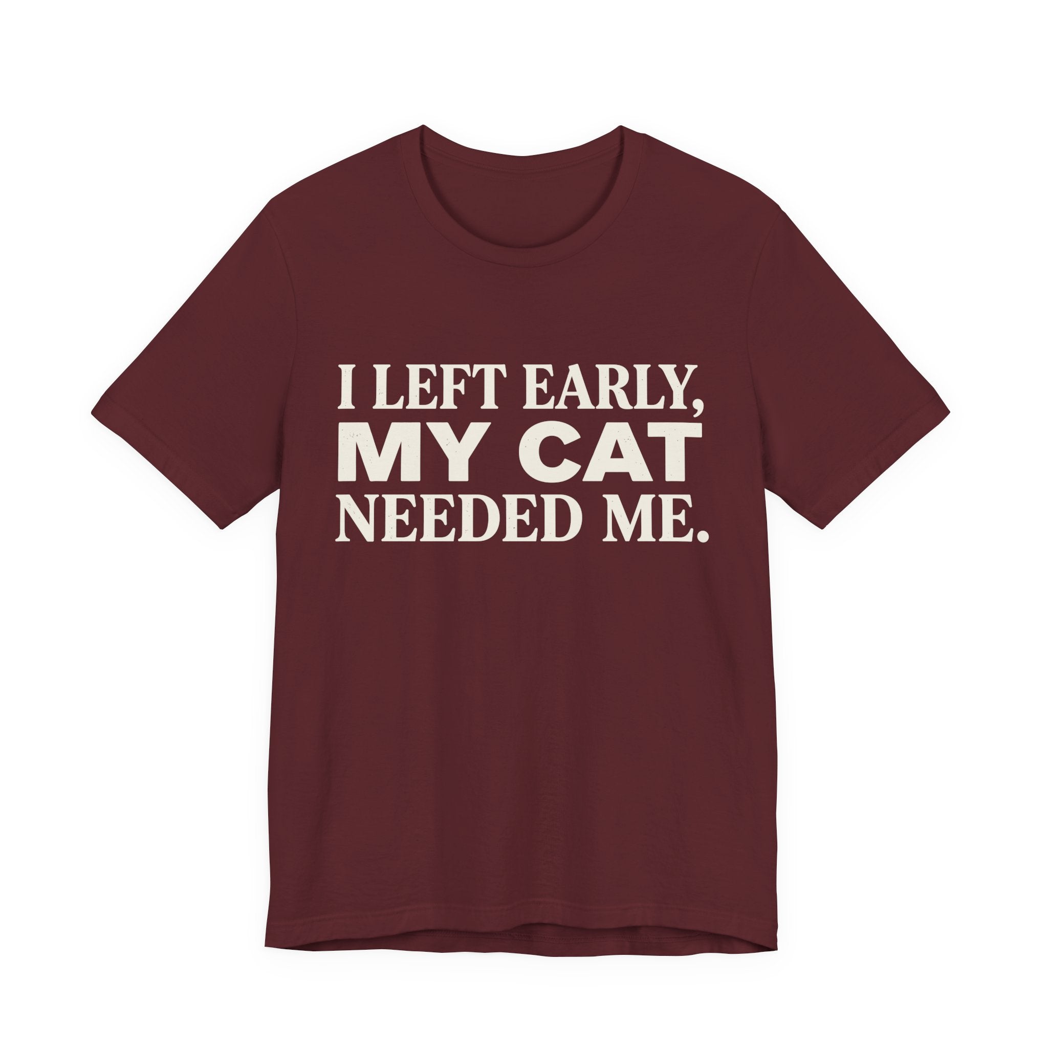 A maroon short-sleeve crewneck t-shirt featuring a graphic with cream text reading “I Left Early, My Cat Needed Me” arranged in three bold lines