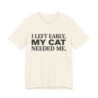 A natural short-sleeve crewneck t-shirt featuring a graphic with black text reading “I Left Early, My Cat Needed Me” arranged in three bold lines

