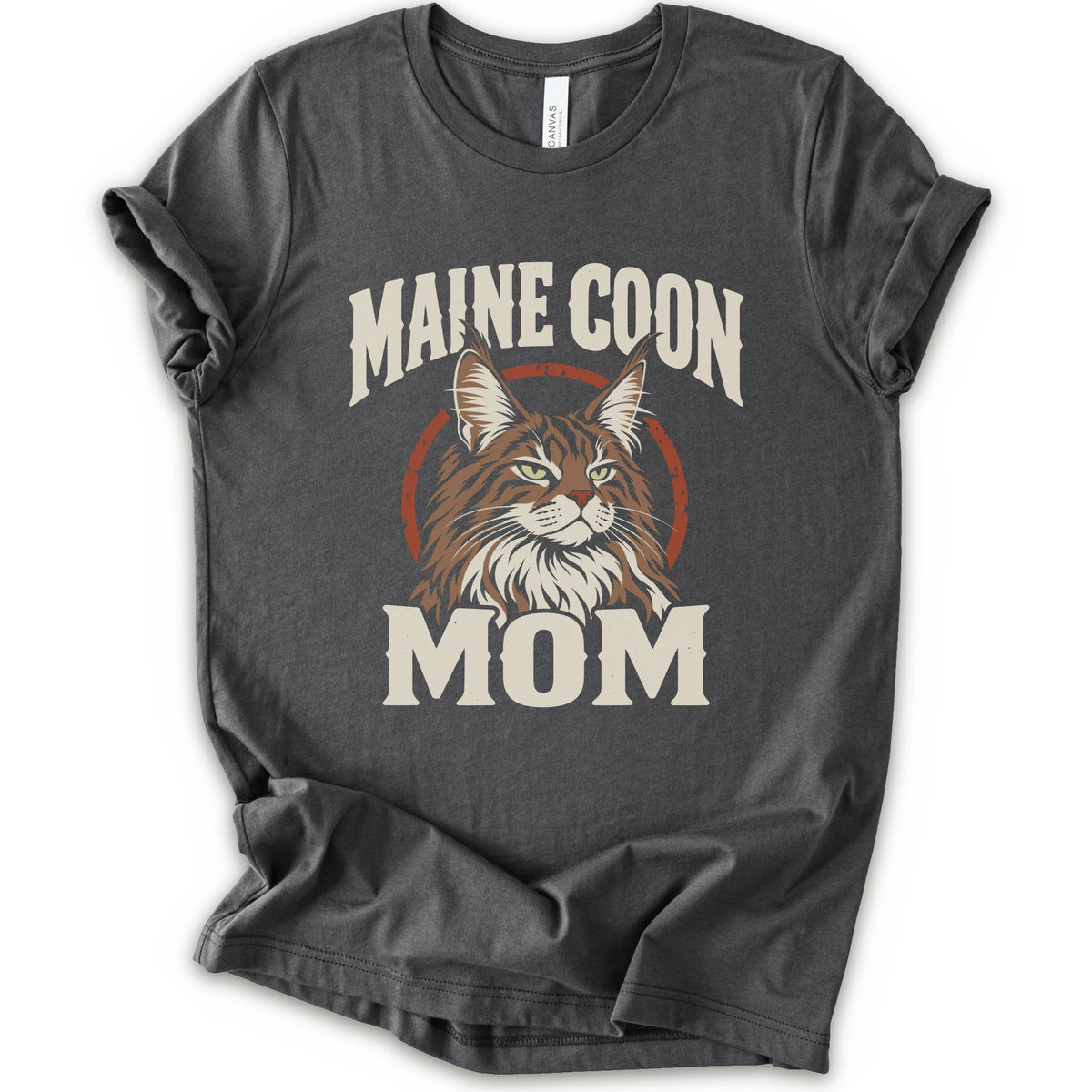 An asphalt short-sleeve crewneck t-shirt featuring a graphic print of a Maine Coon cat with the text 'MAINE COON MOM' in distressed cream lettering.