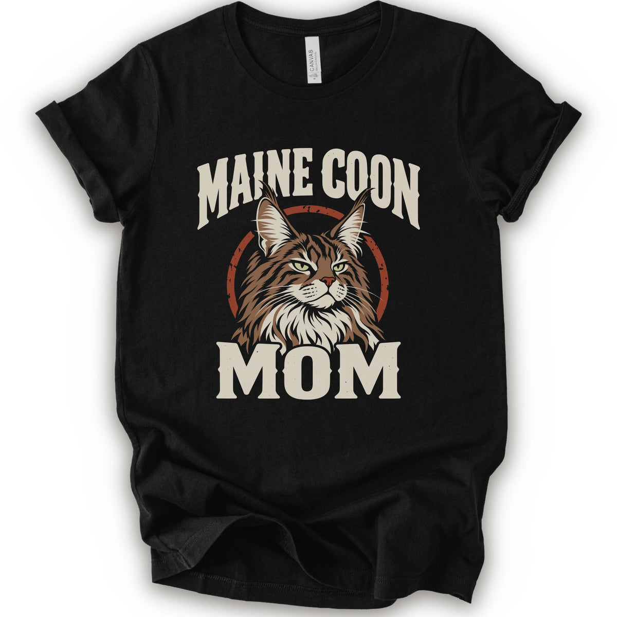 A black short-sleeve crewneck t-shirt featuring a graphic print of a Maine Coon cat with the text 'MAINE COON MOM' in distressed cream lettering.