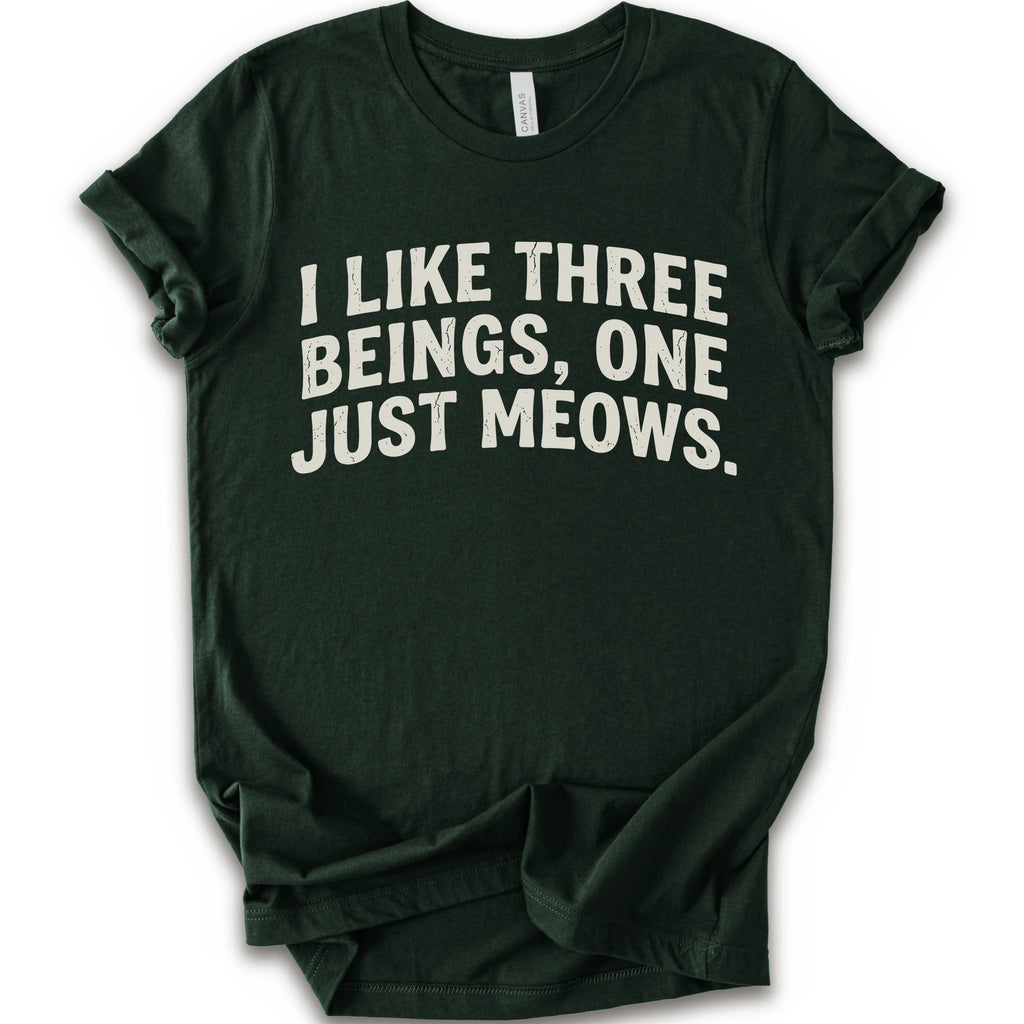 Forest graphic t-shirt with distressed cream text reading “I LIKE THREE BEINGS, ONE JUST MEOWS.” for an introvert cat T-shirt