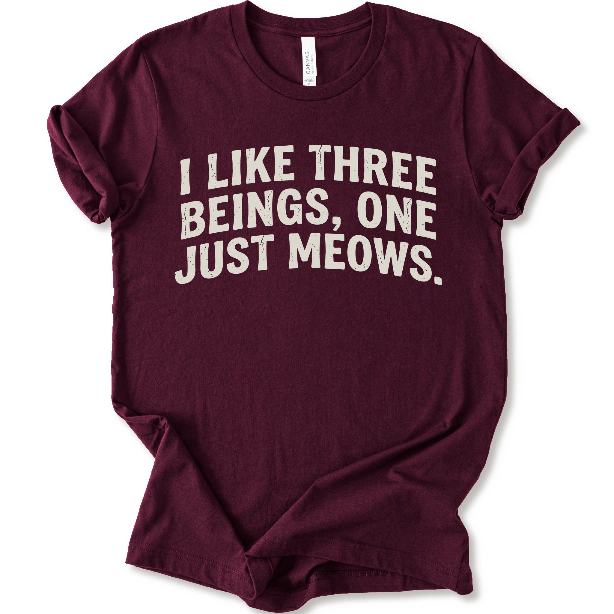 Maroon graphic t-shirt with distressed cream text reading “I LIKE THREE BEINGS, ONE JUST MEOWS.” for an introvert cat T-shirt