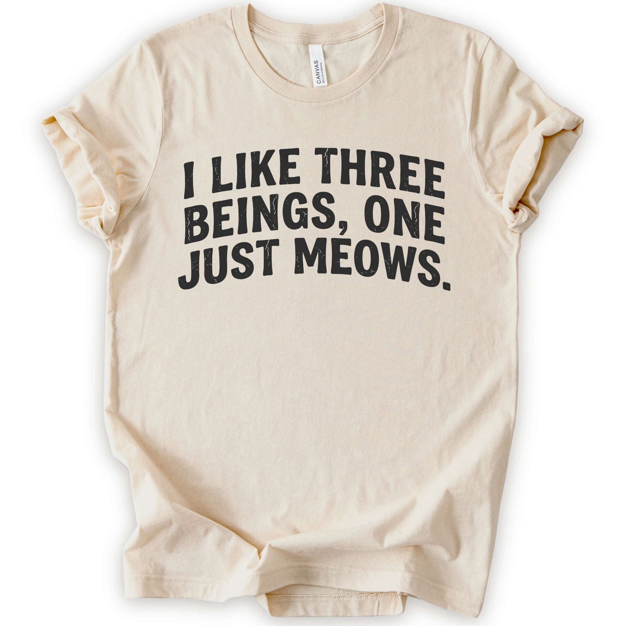 Natural graphic t-shirt with distressed black text reading “I LIKE THREE BEINGS, ONE JUST MEOWS.” for an introvert cat T-shirt
