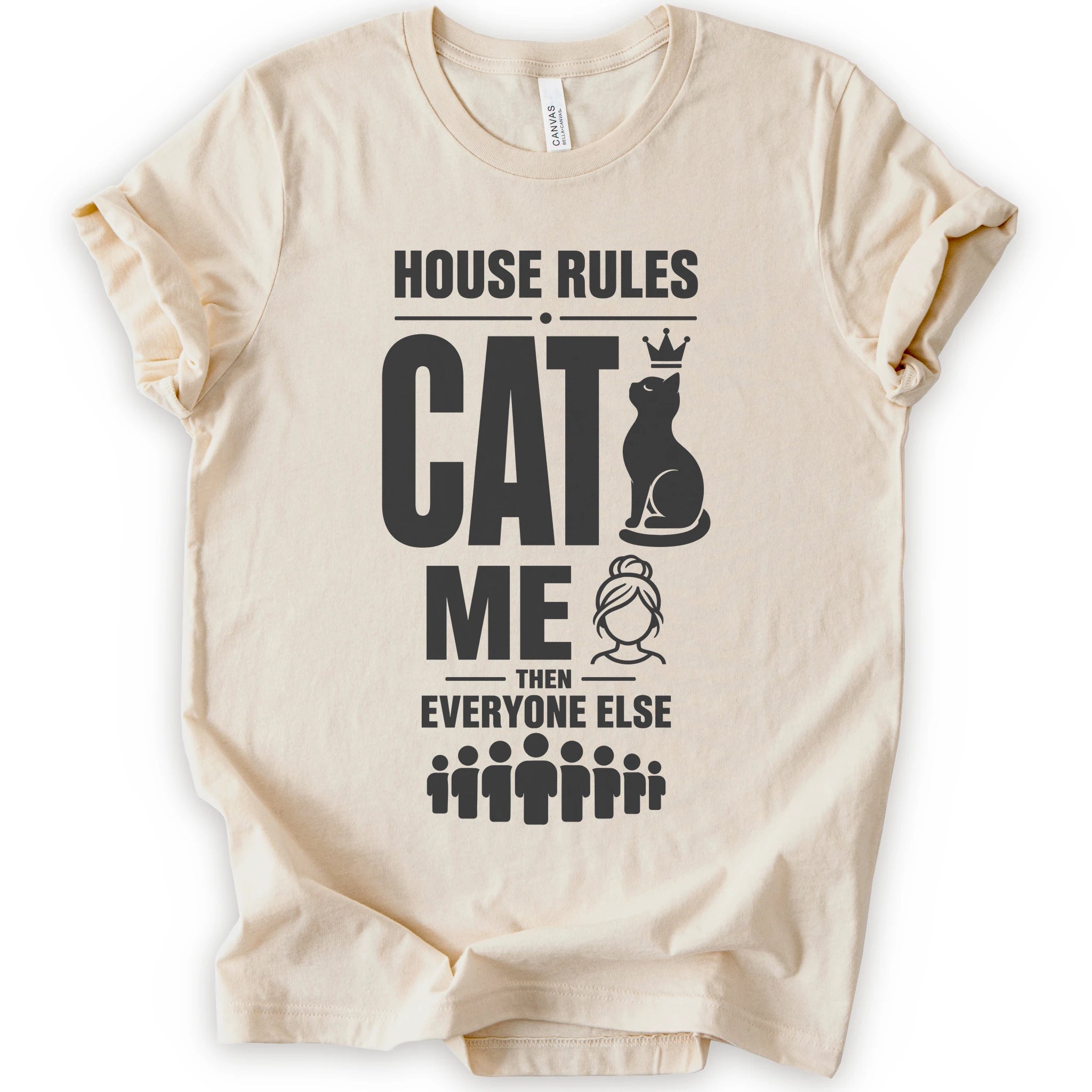 A natural short-sleeve crewneck t-shirt with a black graphic print that reads 'HOUSE RULES CAT ME THEN EVERYONE ELSE' accompanied by illustrations of a cat wearing a crown and stick-figure family members.
