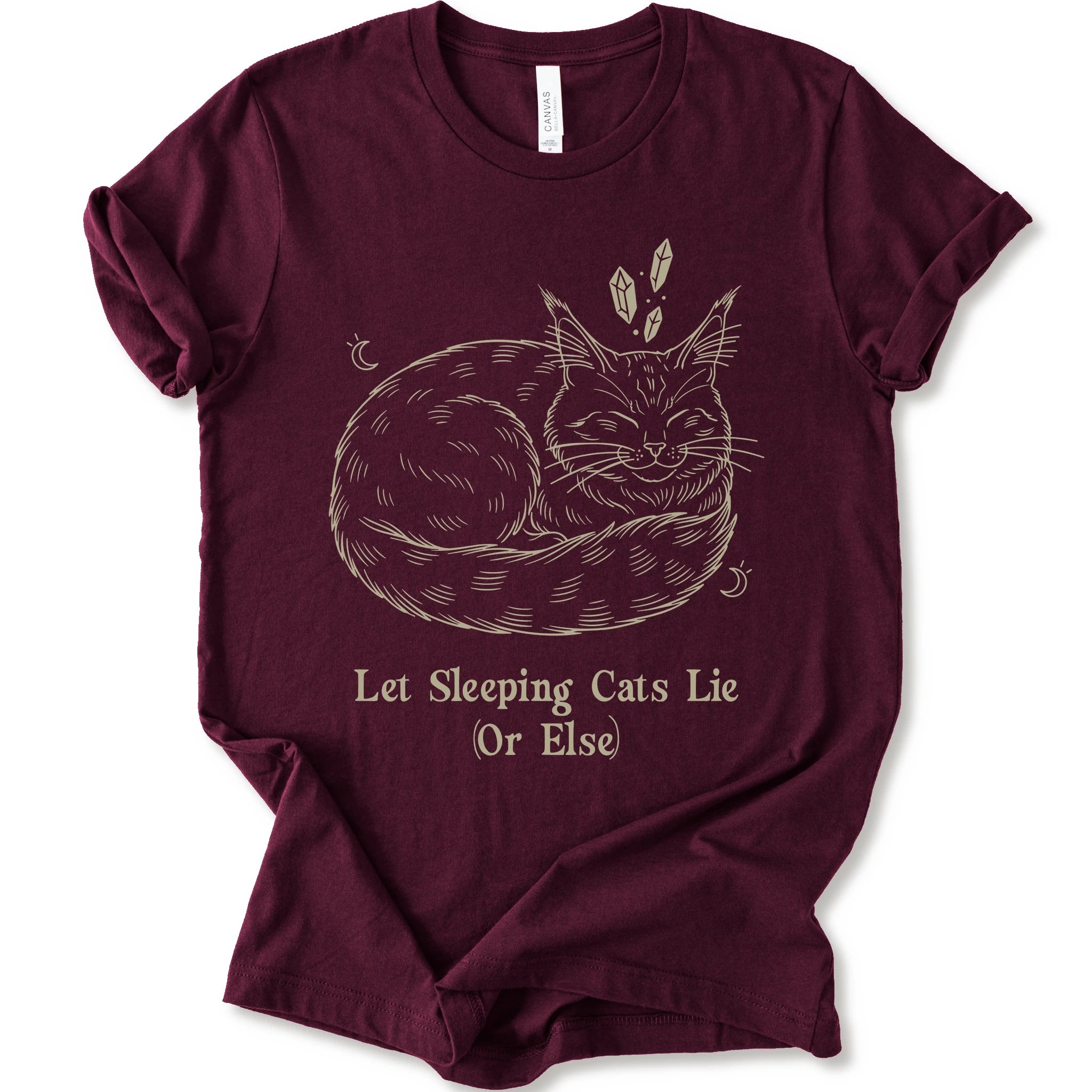 A maroon short-sleeve crewneck t-shirt with a graphic of a sleeping maine coon cat in beige line art, accompanied by the text 'Let Sleeping Cats Lie (Or Else)'.