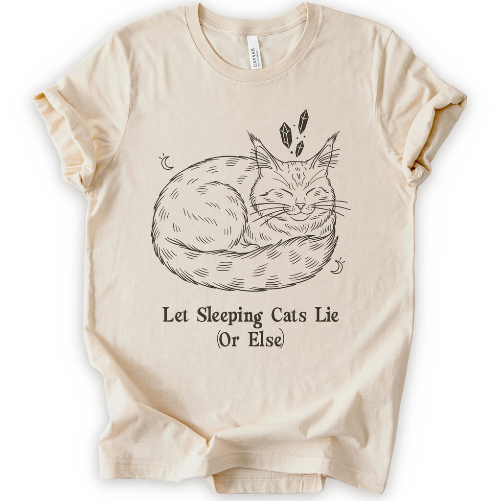 A natural short-sleeve crewneck t-shirt with a graphic of a sleeping maine coon cat in black line art, accompanied by the text 'Let Sleeping Cats Lie (Or Else)'.