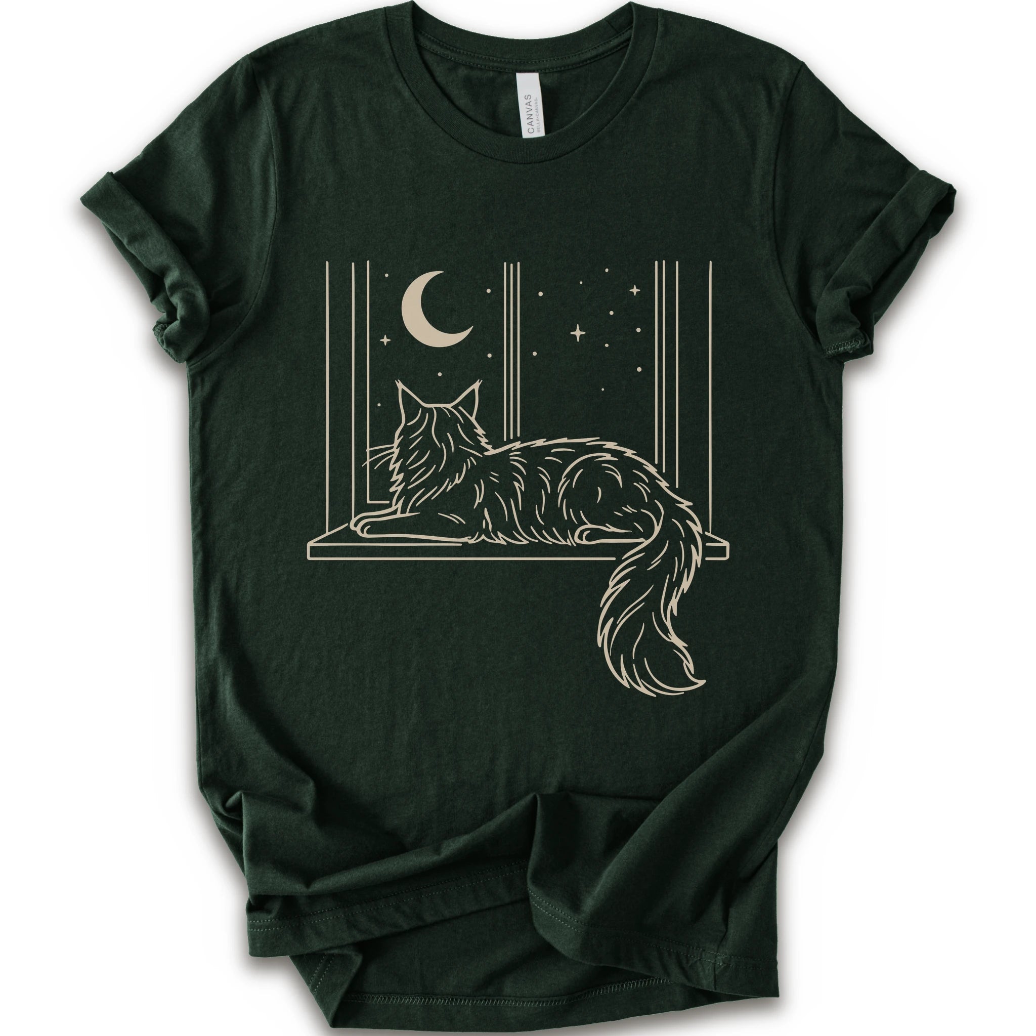 A forest short-sleeve crewneck t-shirt with a graphic print of a long-haired maine coon resting on a windowsill under a crescent moon and stars.