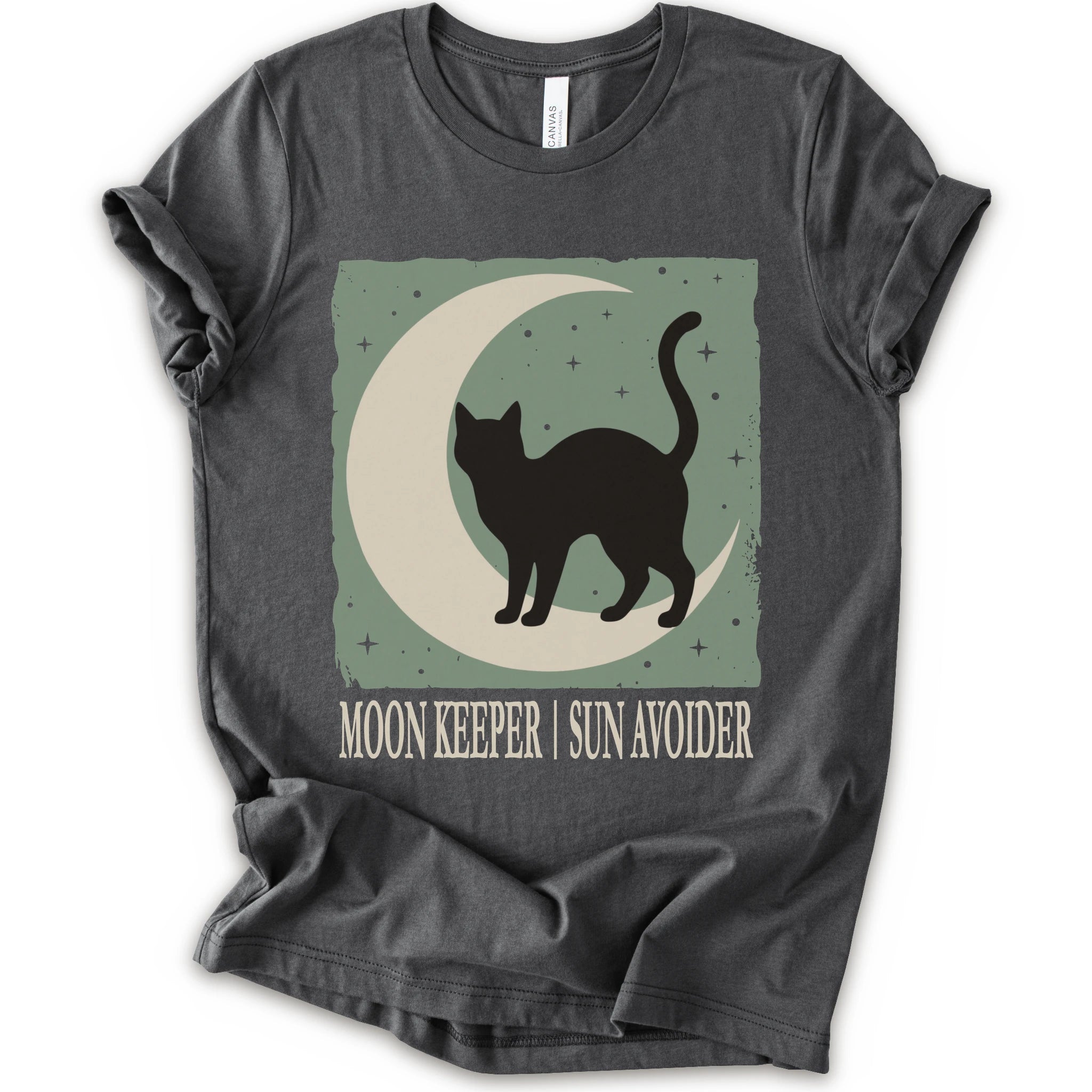 A asphalt short-sleeve crewneck t-shirt with a graphic print of a black cat silhouette walking on a crescent moon against a sage green starry background, with the text 'MOON KEEPER | SUN AVOIDER' printed below.