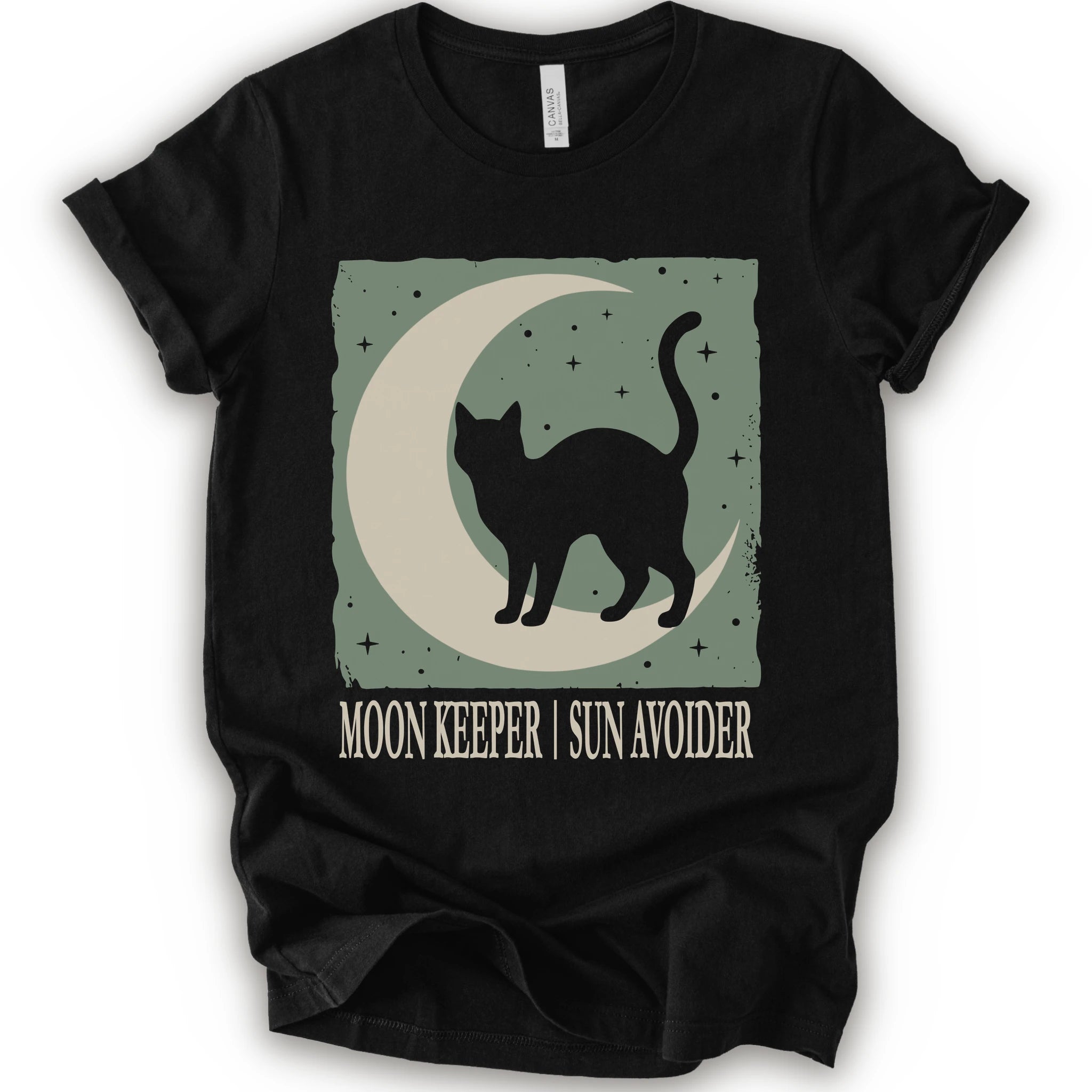 A black short-sleeve crewneck t-shirt with a graphic print of a black cat silhouette walking on a crescent moon against a sage green starry background, with the text 'MOON KEEPER | SUN AVOIDER' printed below.