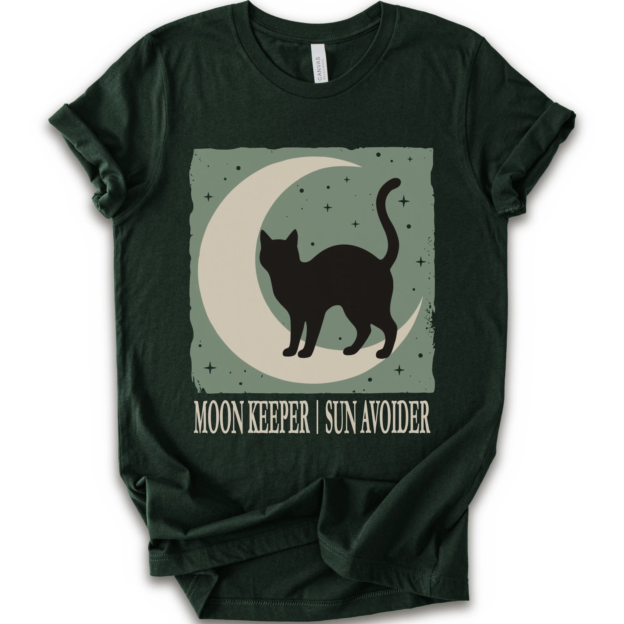 A forest short-sleeve crewneck t-shirt with a graphic print of a black cat silhouette walking on a crescent moon against a sage green starry background, with the text 'MOON KEEPER | SUN AVOIDER' printed below.