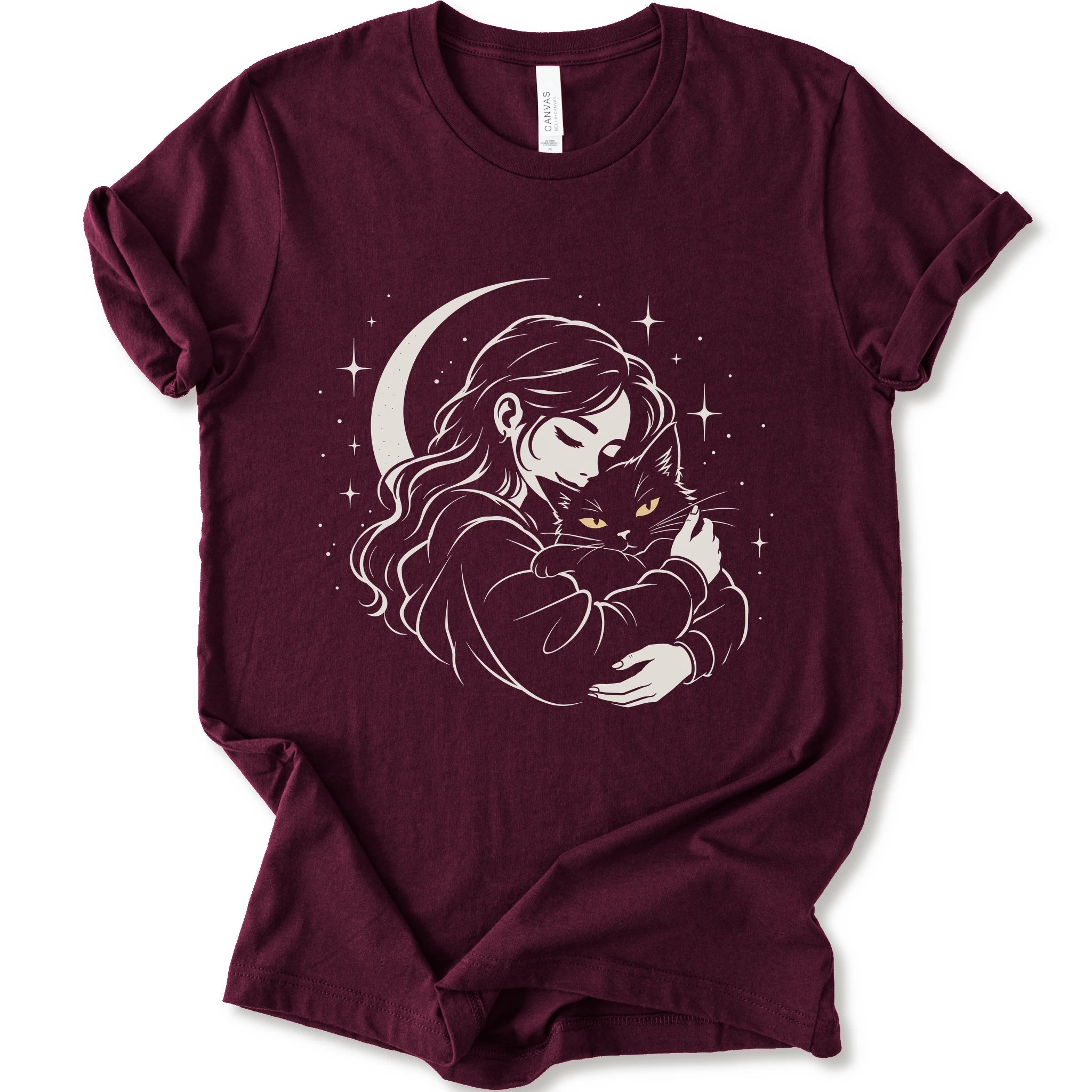Maroon graphic t-shirt with a woman hugging a fluffy cat beneath a crescent moon and stars, drawn in cream lines with golden cat eyes