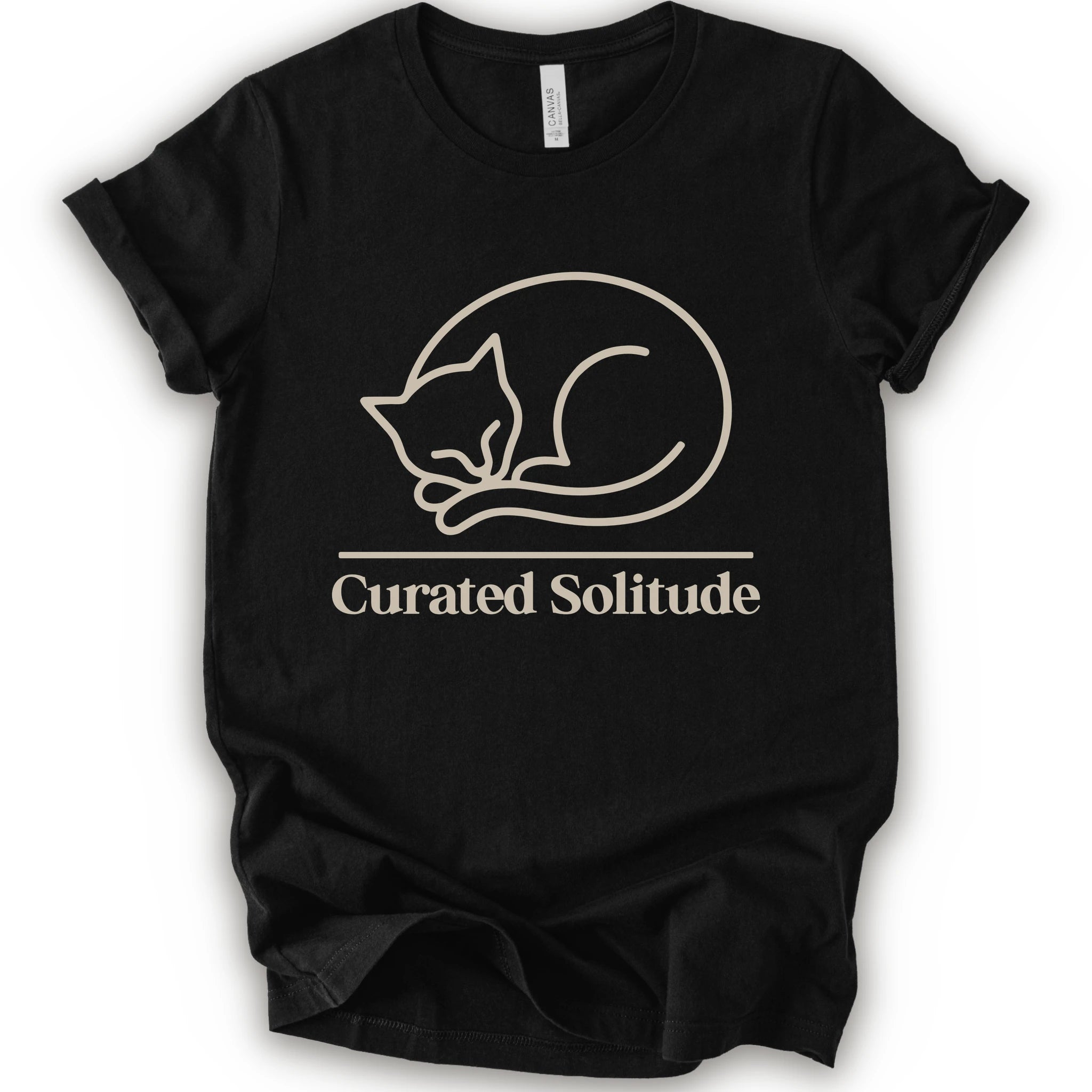 A black short-sleeve crewneck t-shirt with a cream-colored graphic of a curled-up sleeping cat, with the text 'Curated Solitude' printed below.