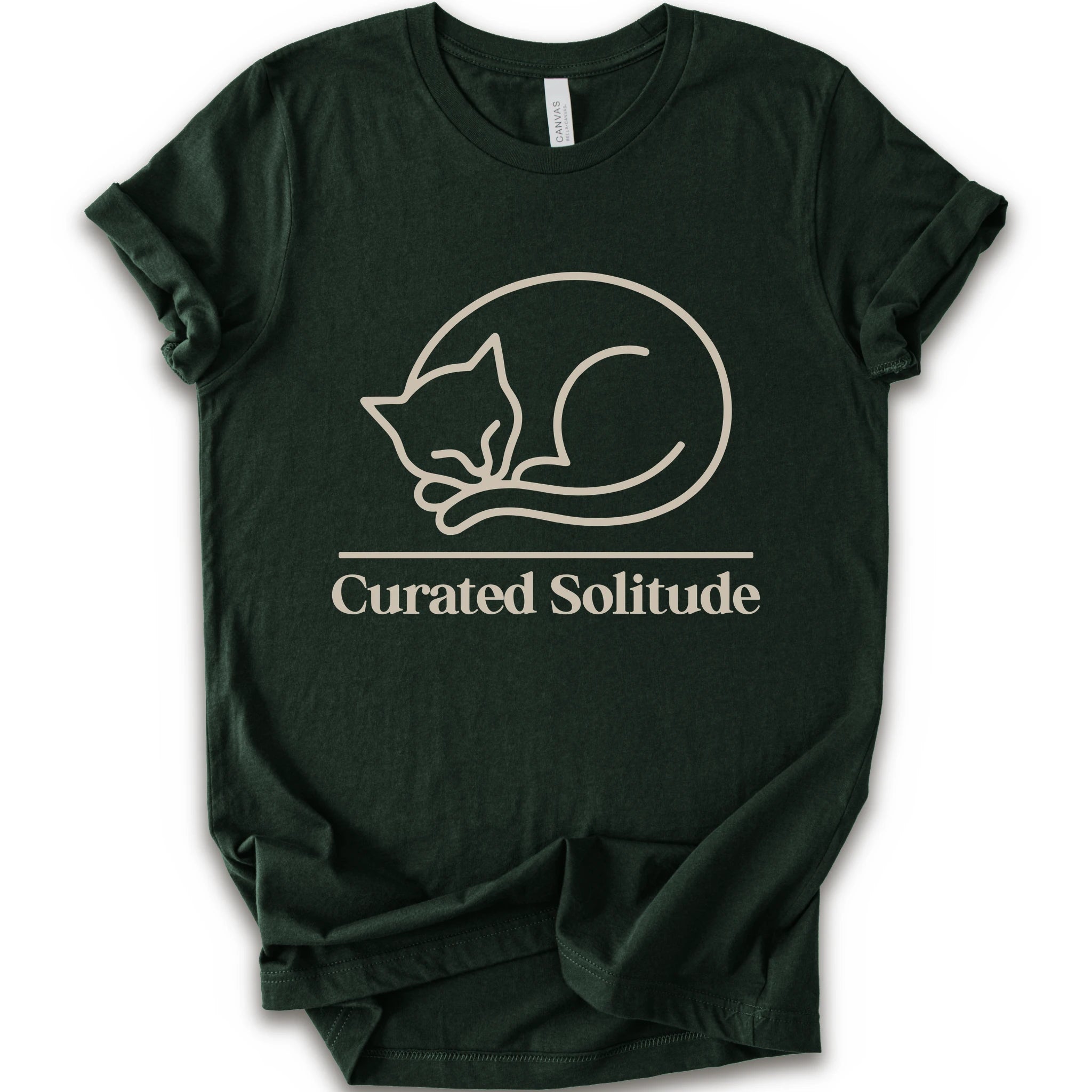 A forest short-sleeve crewneck t-shirt with a cream-colored graphic of a curled-up sleeping cat, with the text 'Curated Solitude' printed below.