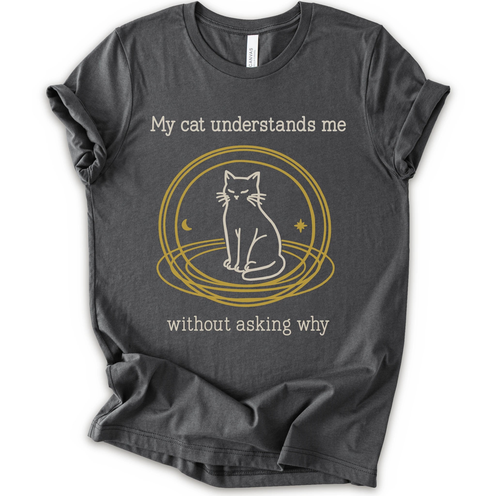 A asphalt t-shirt with a graphic of a white cat sitting inside a gold circular frame, with the text 'My cat understands me without asking why' in a light beige font.