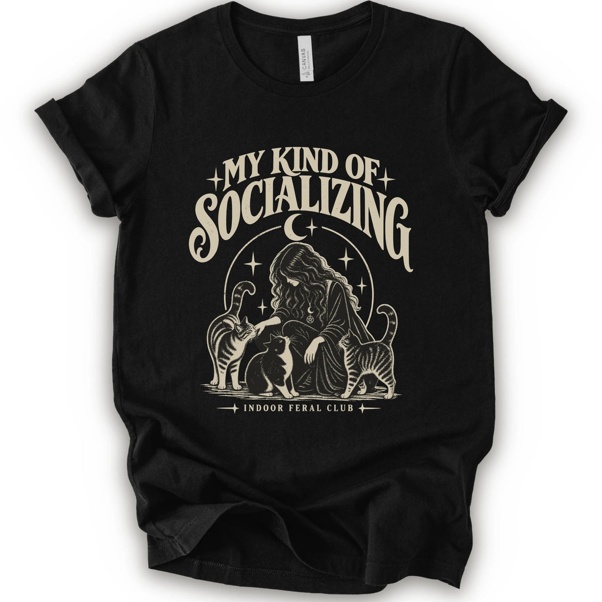 A black short-sleeve t-shirt with a cream-colored graphic print on the front. The graphic features the text 'MY KIND OF SOCIALIZING' in a stylized font above an illustration of a woman surrounded by cats under a crescent moon, with 'INDOOR FERAL CLUB' printed below.
