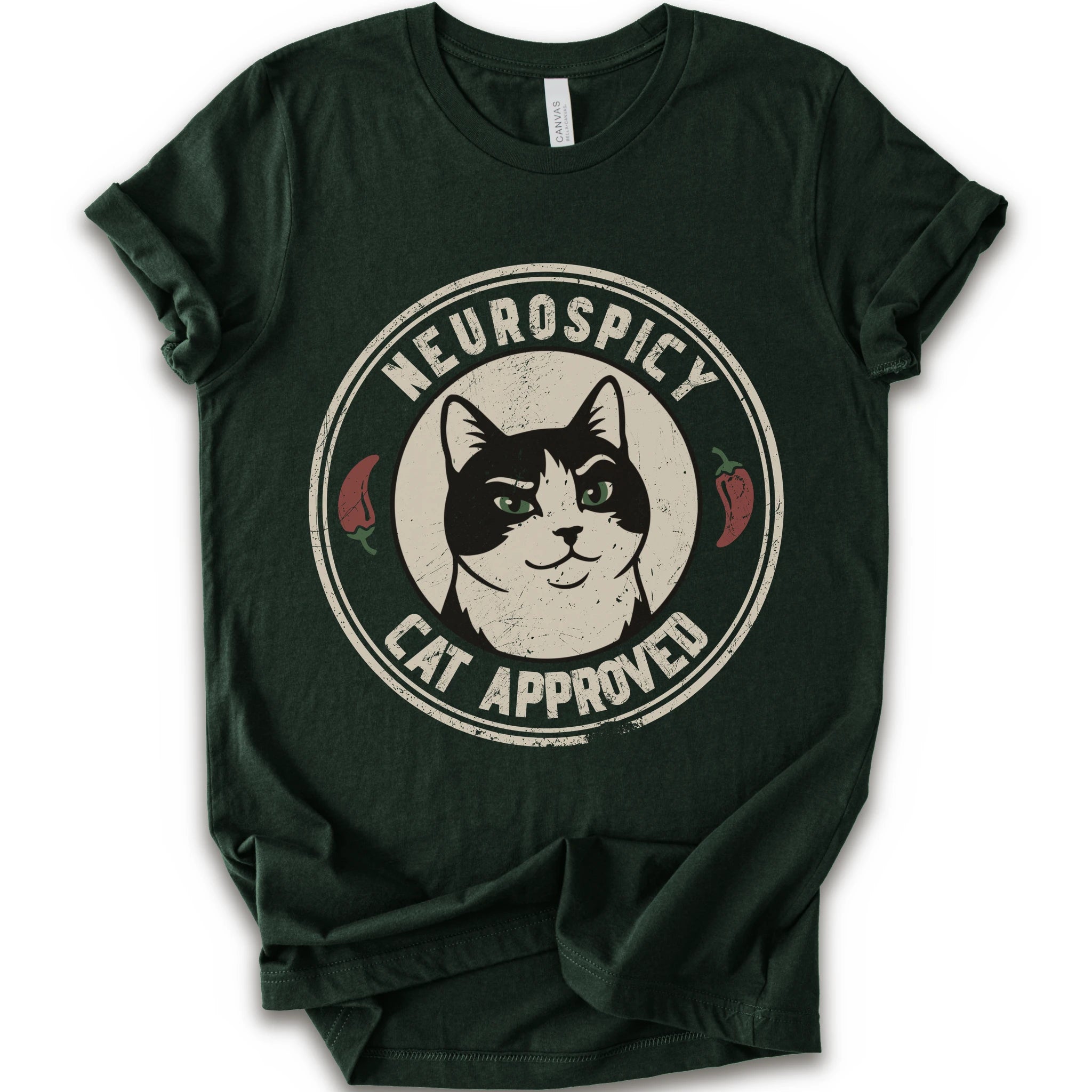 A forest short-sleeve crewneck t-shirt with a distressed circular graphic on the chest featuring a black and white cat with green eyes, red peppers, and the text 'NEUROSPICY, CAT APPROVED'.