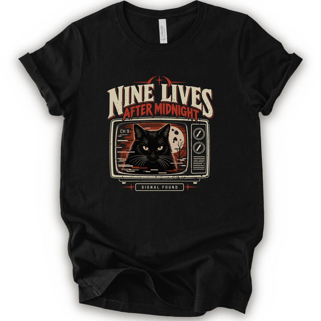 A black short-sleeve crewneck t-shirt with a vintage-style graphic on the front. The graphic features the text 'NINE LIVES AFTER MIDNIGHT' in distressed cream and red lettering above an illustration of a black cat's face on a retro television screen, with 'SIGNAL FOUND' written below.