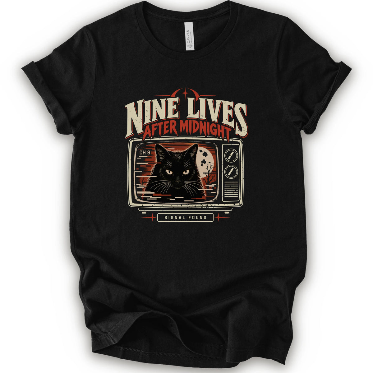 A black short-sleeve crewneck t-shirt with a vintage-style graphic on the front. The graphic features the text 'NINE LIVES AFTER MIDNIGHT' in distressed cream and red lettering above an illustration of a black cat's face on a retro television screen, with 'SIGNAL FOUND' written below.