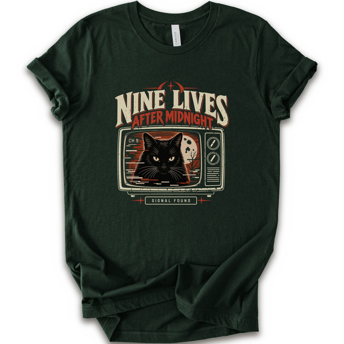 A forest short-sleeve crewneck t-shirt with a vintage-style graphic on the front. The graphic features the text 'NINE LIVES AFTER MIDNIGHT' in distressed cream and red lettering above an illustration of a black cat's face on a retro television screen, with 'SIGNAL FOUND' written below.