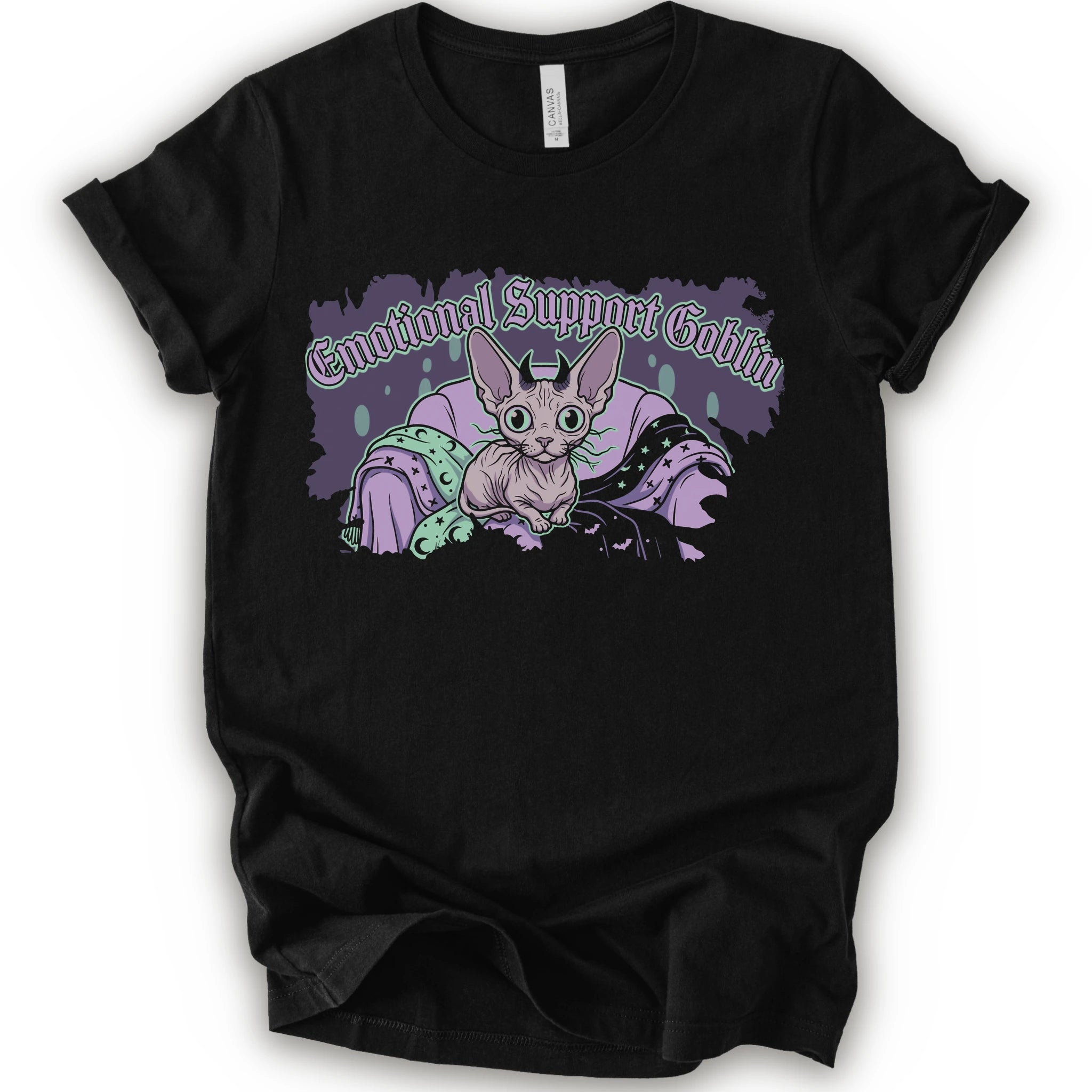 A black short-sleeve t-shirt with a graphic print of a cartoon sphynx cat in a purple blanket with the text 'Emotional Support Goblin'.