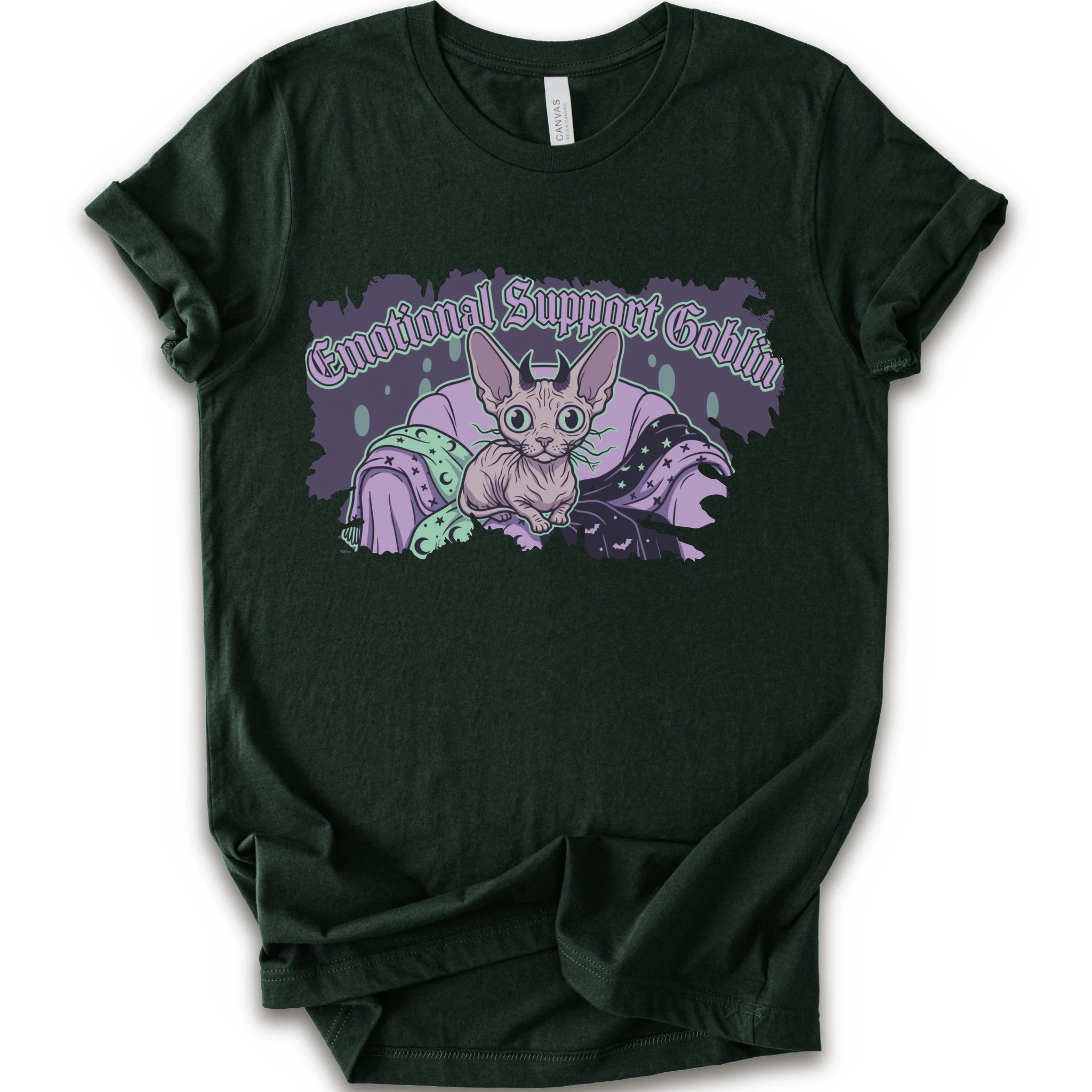 A forest short-sleeve t-shirt with a graphic print of a cartoon sphynx cat in a purple blanket with the text 'Emotional Support Goblin'.