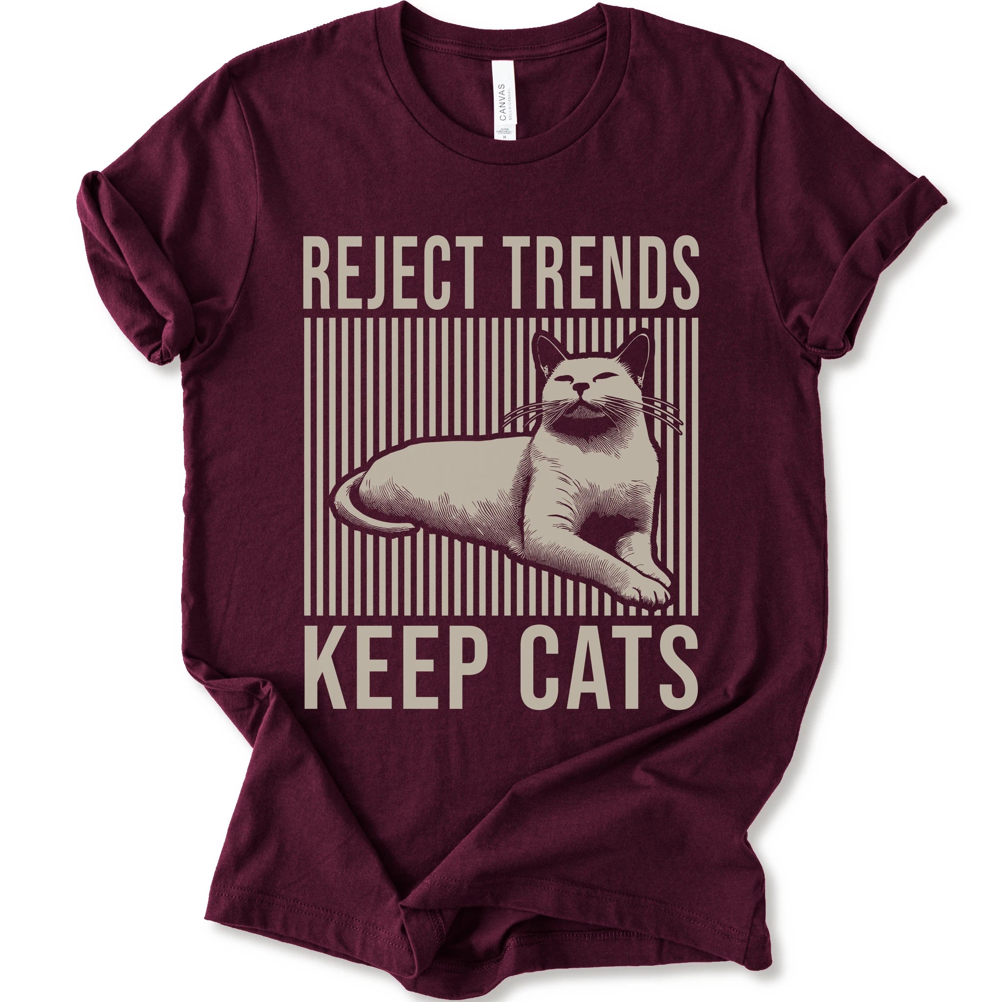 A maroon short-sleeve t-shirt with a vintage-style graphic featuring a cat and the text 'REJECT TRENDS KEEP CATS' in beige.