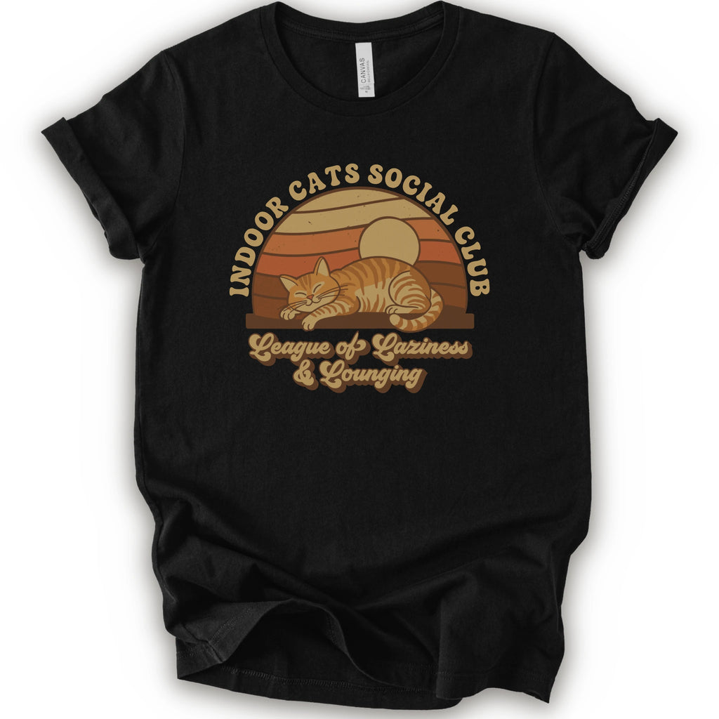 A black short-sleeve crewneck t-shirt featuring a retro-style graphic of an orange tabby cat sleeping under a sunset, with the text 'INDOOR CATS SOCIAL CLUB' and 'League of Laziness & Lounging'.