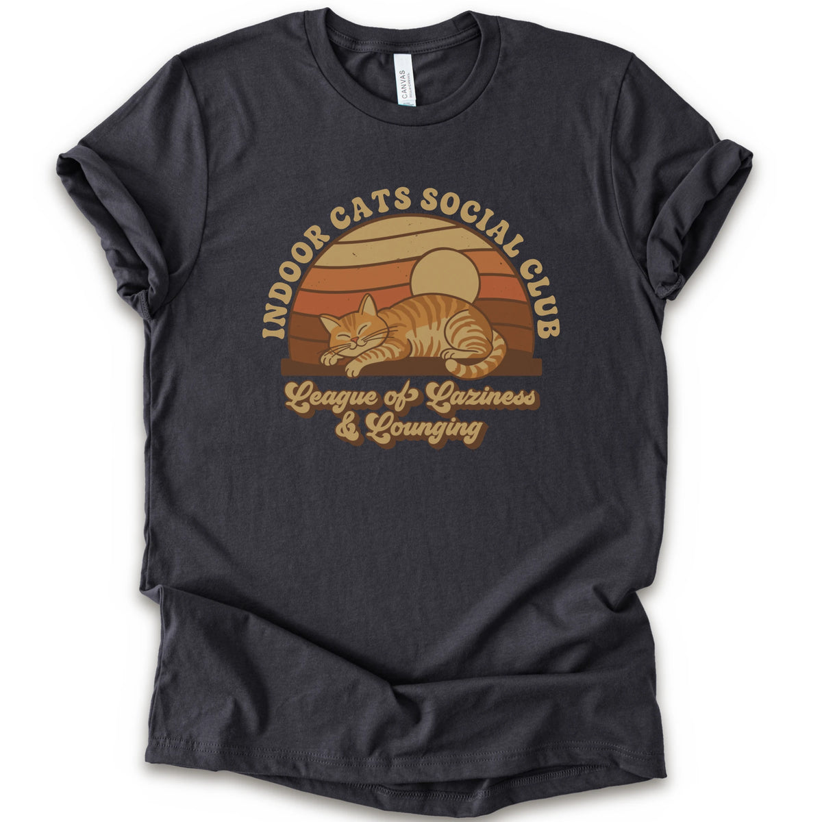A dark grey short-sleeve crewneck t-shirt featuring a retro-style graphic of an orange tabby cat sleeping under a sunset, with the text 'INDOOR CATS SOCIAL CLUB' and 'League of Laziness & Lounging'.