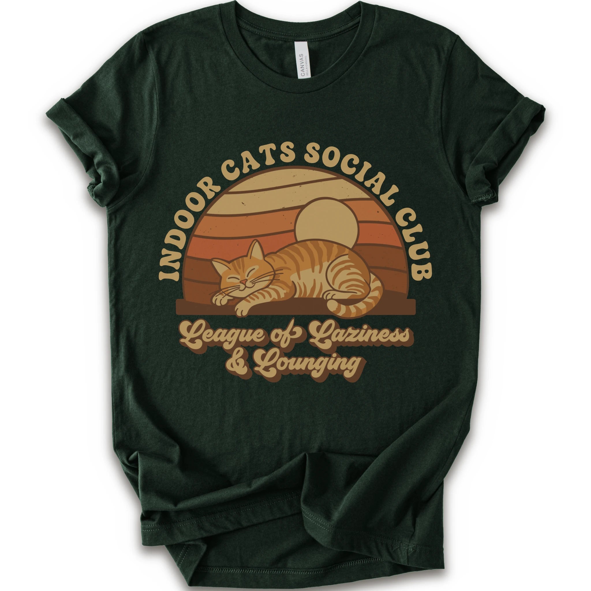 A forest short-sleeve crewneck t-shirt with a retro-style graphic of an orange tabby cat sleeping under a sunset, with the text 'INDOOR CATS SOCIAL CLUB' and 'League of Laziness & Younging'.