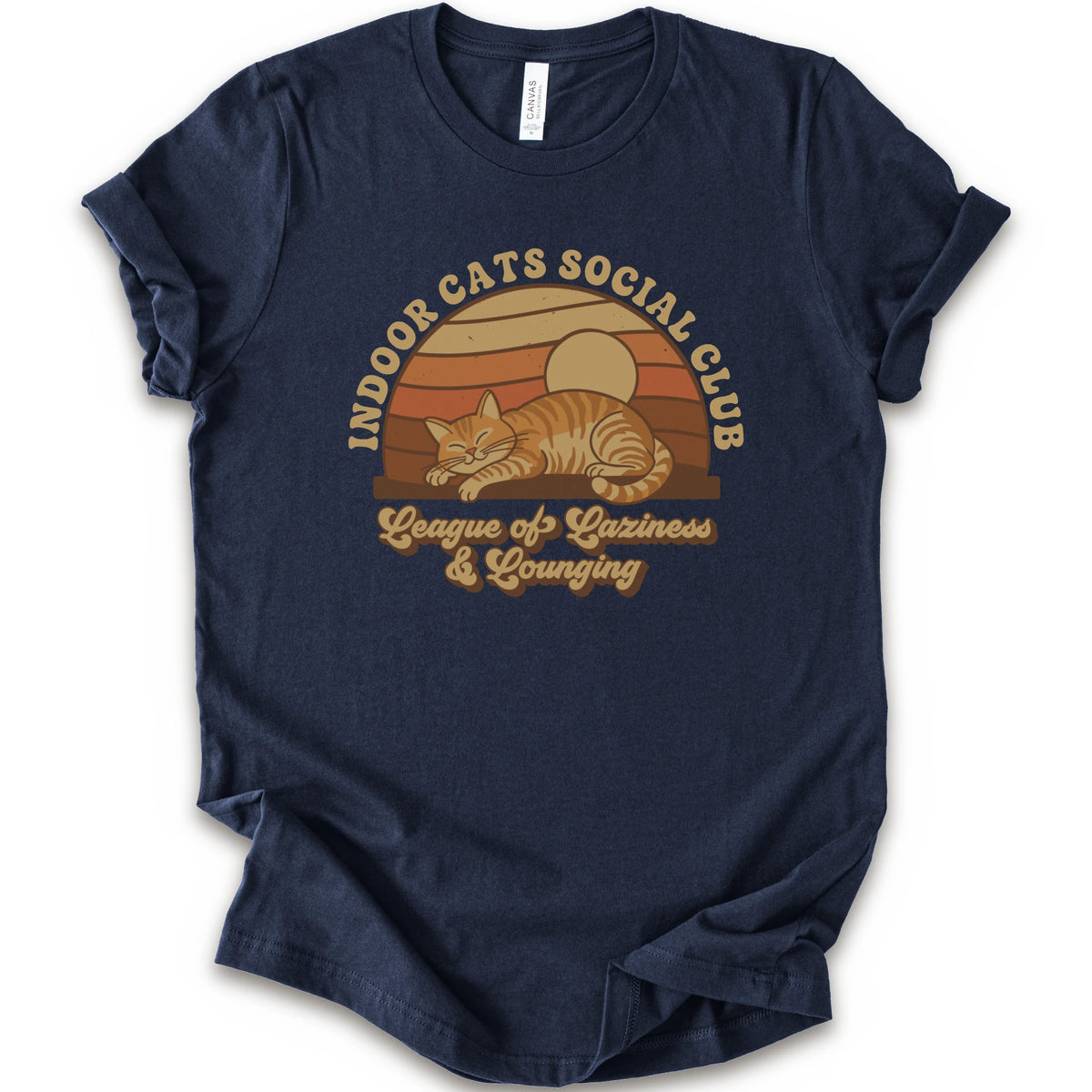 A navy short-sleeve crewneck t-shirt featuring a retro-style graphic of an orange tabby cat sleeping under a sunset, with the text 'INDOOR CATS SOCIAL CLUB' and 'League of Laziness & Lounging'.