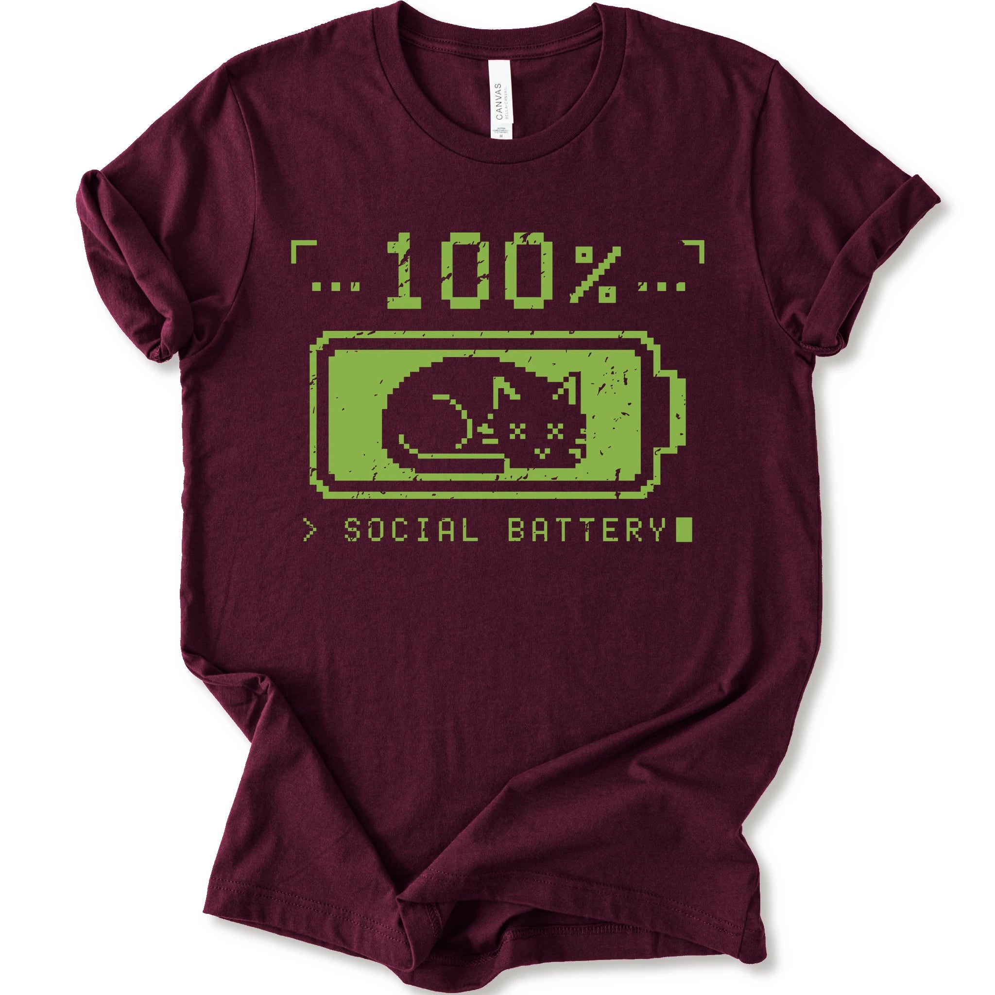 A maroon t-shirt with a green pixel-art graphic of a sleeping cat inside a battery icon, with the text '100% SOCIAL BATTERY'.