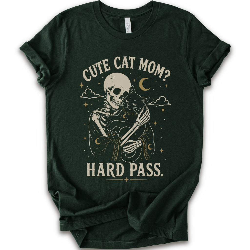 A forest short-sleeve crewneck t-shirt with a vintage-style graphic of a skeleton cat holding a black cat under the text 'CUTE CAT MOM? HARD PASS.' in a distressed cream color.