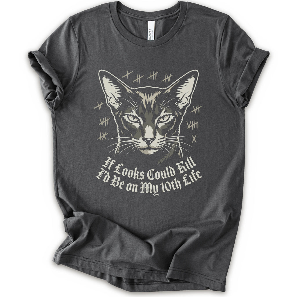 A asphalt short-sleeve crewneck t-shirt featuring a graphic print of a cat's face with tally marks and the text 'It Looks Could Fill I'd Be on My 10th Life' in a white gothic font.