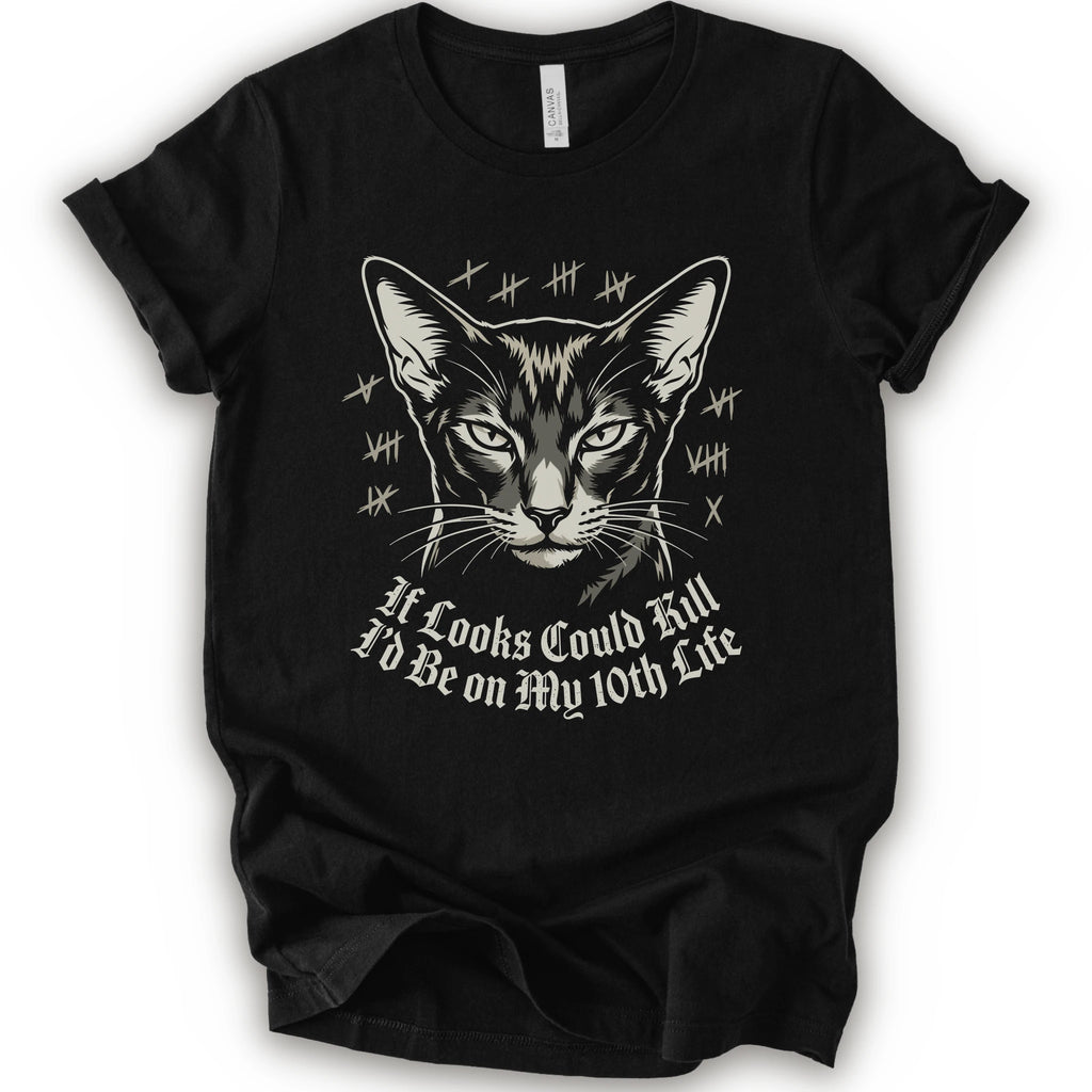 A black short-sleeve crewneck t-shirt featuring a graphic print of a cat's face with tally marks and the text 'It Looks Could Fill I'd Be on My 10th Life' in a white gothic font.