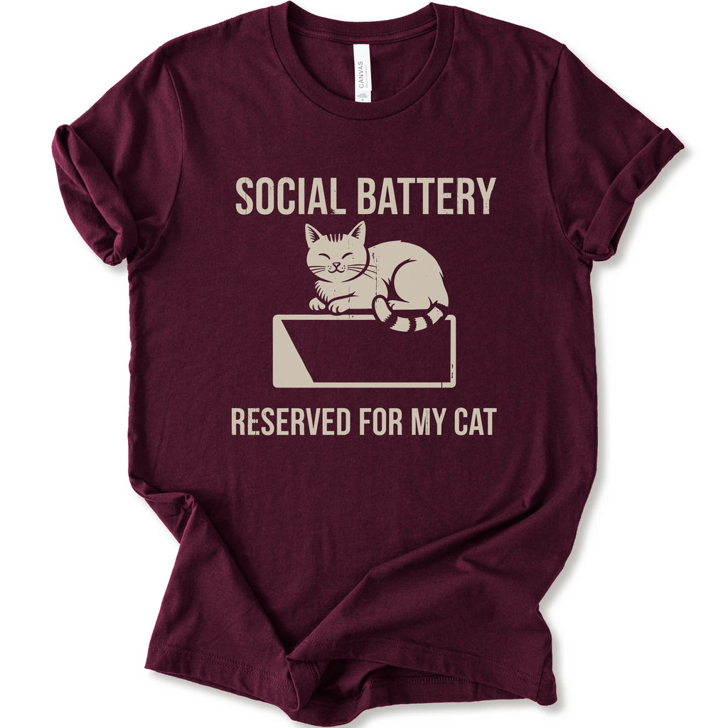 A maroon short-sleeve crewneck T-shirt with a cat on a low battery graphic and “Social Battery Reserved for My Cat” text.