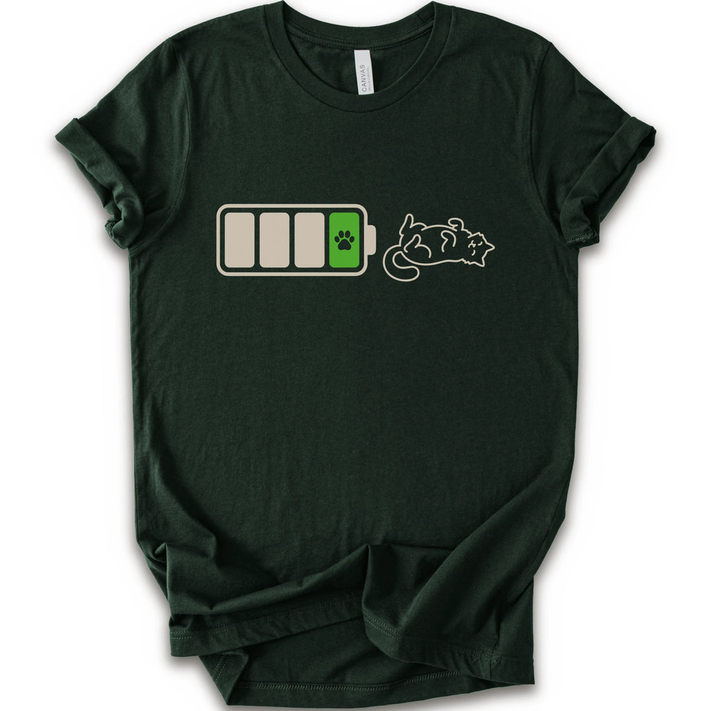 A forest short-sleeve crewneck t-shirt featuring a graphic of a battery with three bars, a green battery cell with a black paw print, and a white line-art illustration of a sleeping cat.