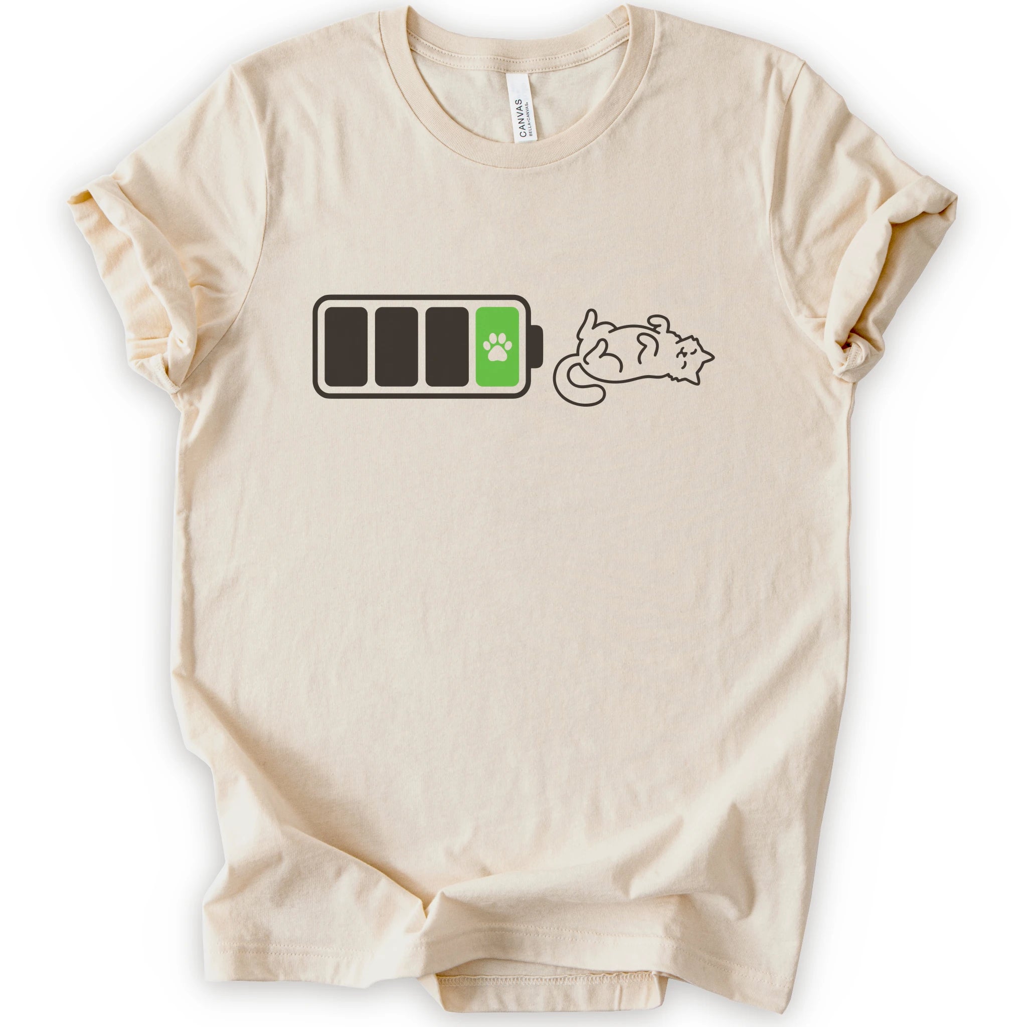 A natural short-sleeve crewneck t-shirt featuring a graphic of a battery with three bars, a green battery cell with a black paw print, and a brown line-art illustration of a sleeping cat.