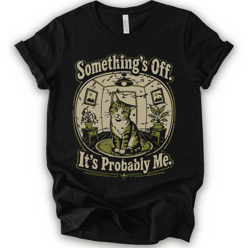 A black short-sleeve crewneck t-shirt with a vintage-style graphic of a cat in a hat inside a circular room, with the text 'Something's Off. It's Probably Me.