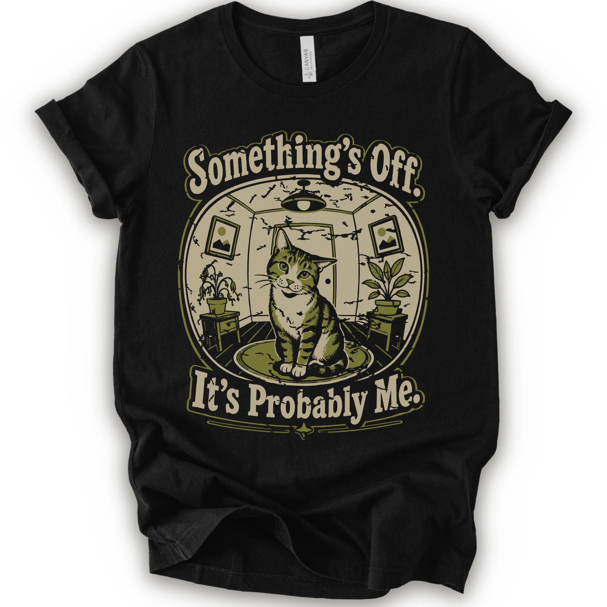 A black short-sleeve crewneck t-shirt with a vintage-style graphic of a cat in a hat inside a circular room, with the text 'Something's Off. It's Probably Me.