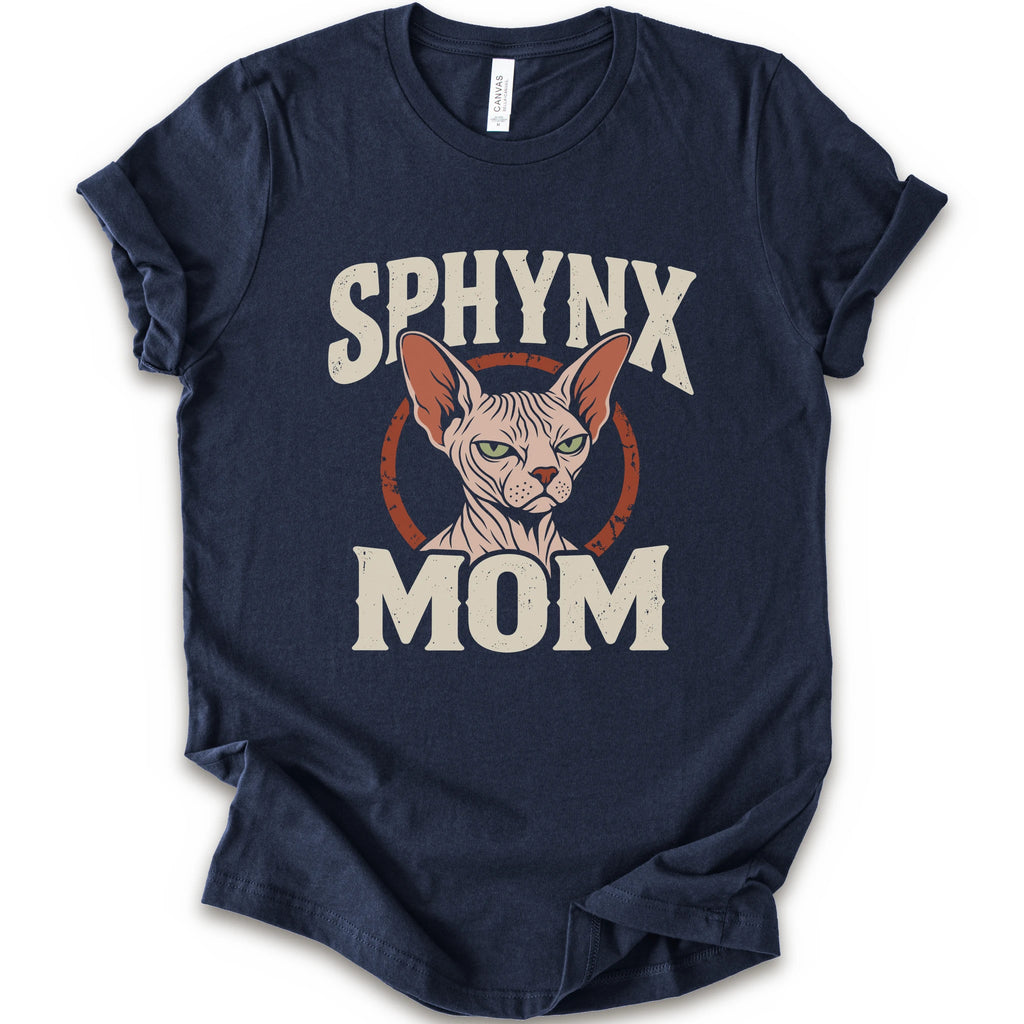 A navy short-sleeve crewneck t-shirt with a graphic print of a Sphynx cat and the text 'SPHYNX MOM' in distressed cream lettering.
