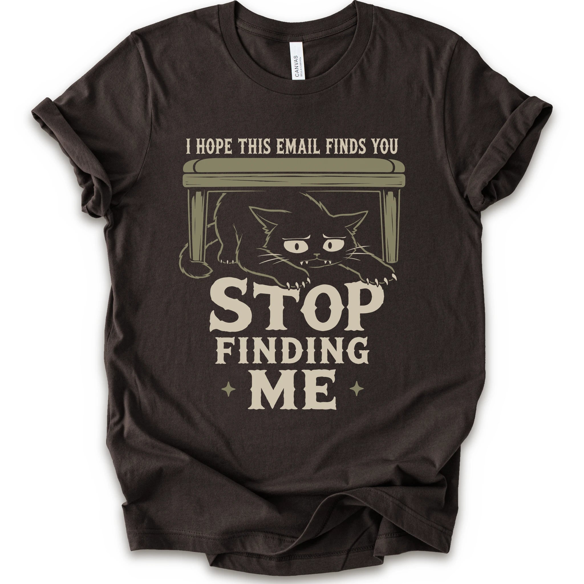 Brown graphic t-shirt with a black cat crouching under a desk with “I Hope This Email Finds You” and “Stop Finding Me” distressed text