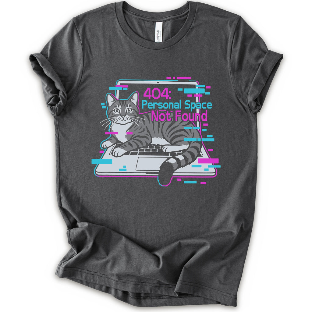 A asphalt short-sleeve crewneck t-shirt with a graphic print of a gray tabby cat sitting in front of a laptop displaying a '404: Personal Space Not Found' error message in pink and cyan text.