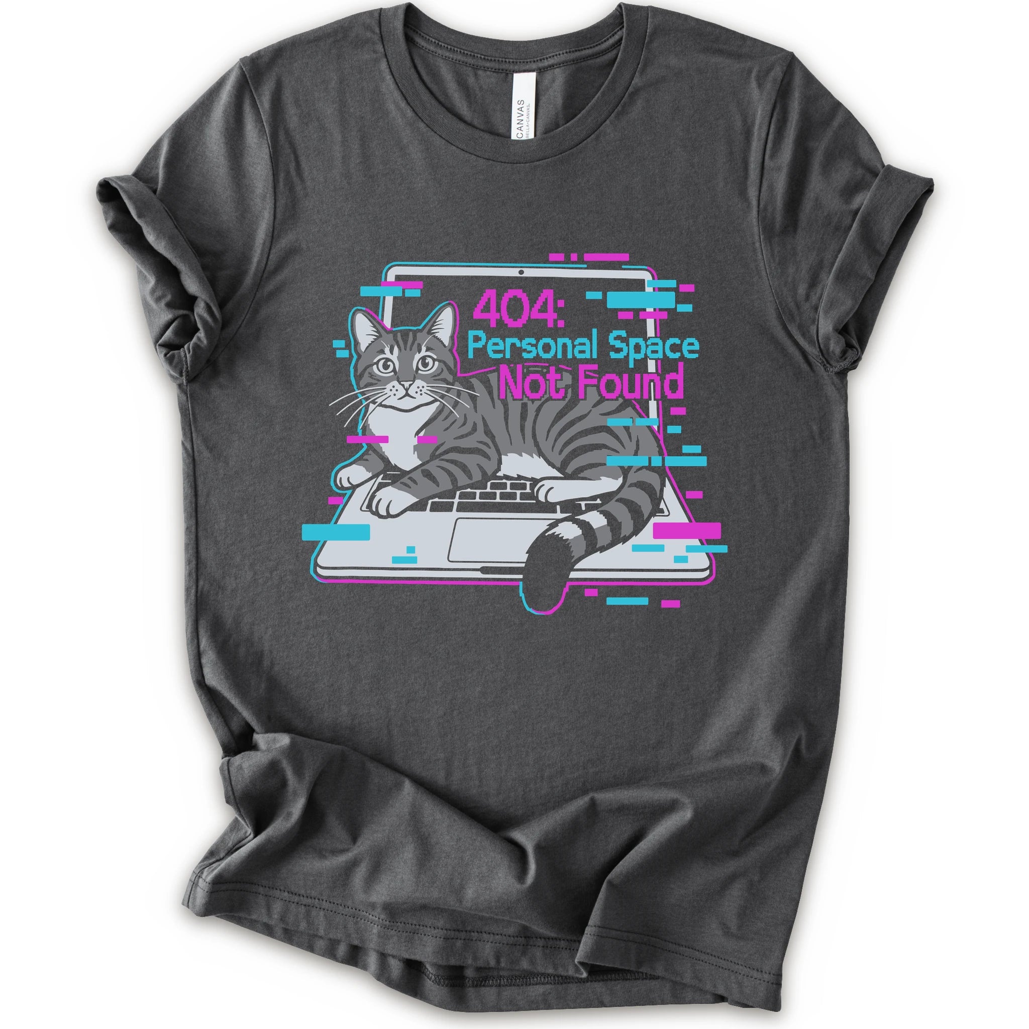 A asphalt short-sleeve crewneck t-shirt with a graphic print of a gray tabby cat sitting in front of a laptop displaying a '404: Personal Space Not Found' error message in pink and cyan text.