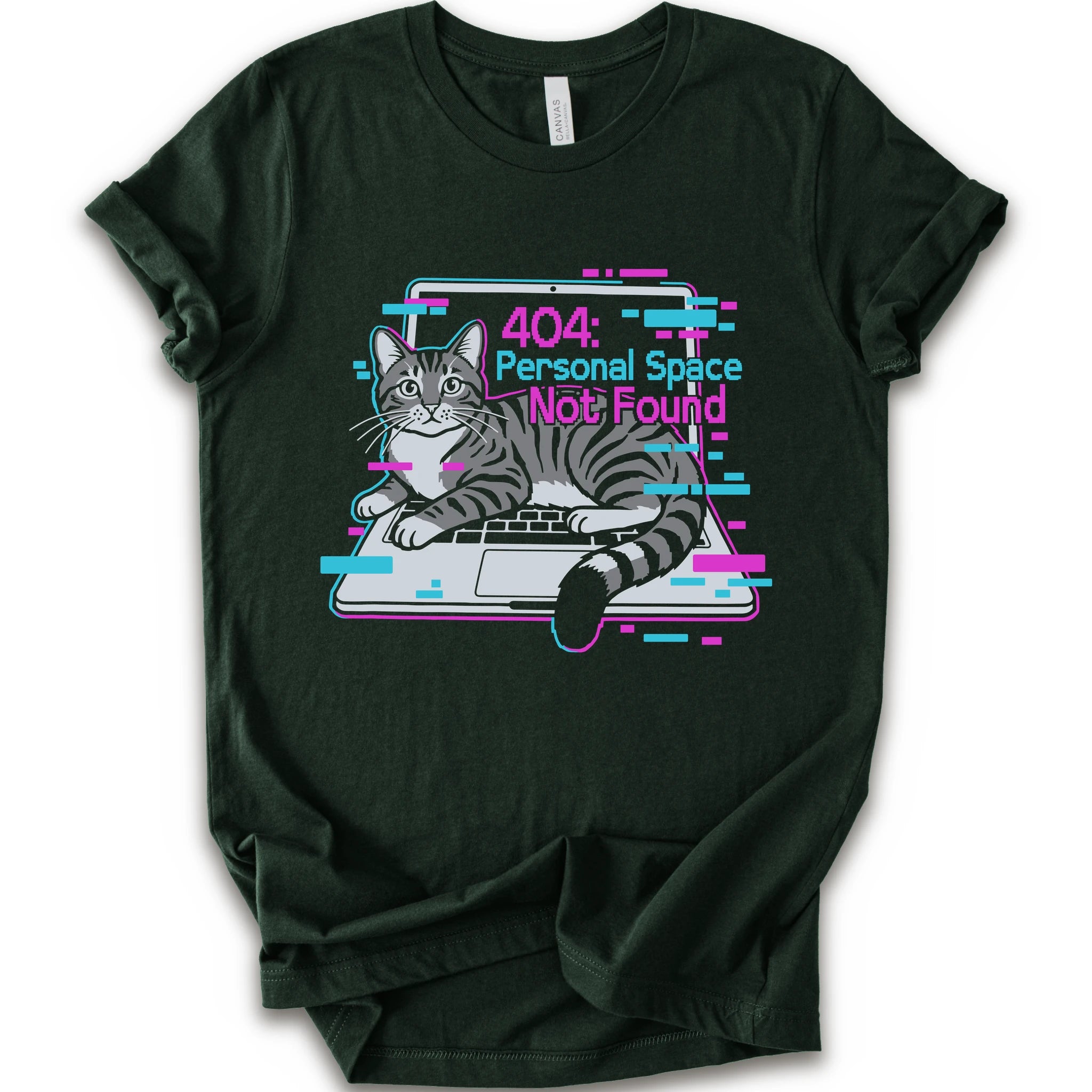 A forest short-sleeve crewneck t-shirt with a graphic print of a gray tabby cat sitting in front of a laptop displaying a '404: Personal Space Not Found' error message in pink and cyan text.